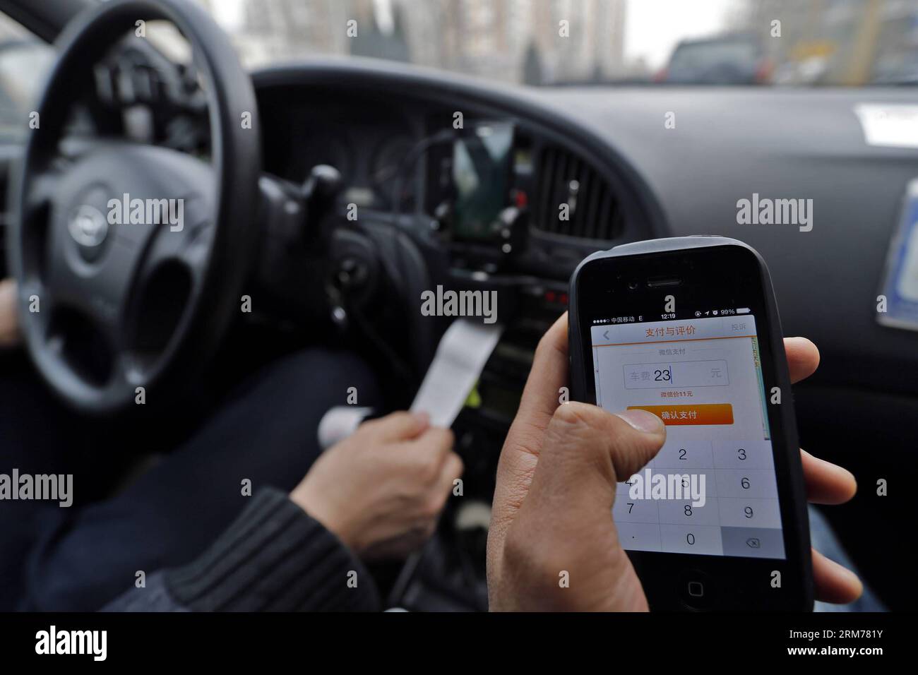 (140218) -- BEIJING, Feb. 18, 2014 (Xinhua) -- A journalist use Didi, a cab-hailing app to pay the bill in Beijing, capital of China, Feb. 18, 2014. Alipay, the country s largest third-party online payment platform and a subsidiary of Alibaba Group, has invested heavily in cab-hailing app KuaiDi on payment subsidies to promote its online payment service. The move came on the heels of a similar subsidy program by cab-hailing app Didi, with investment from Tencent. Didi s incentive, announced early January, encourages passengers to pay taxi fares via Tencent s WeChat, a multi-media app combining Stock Photo
