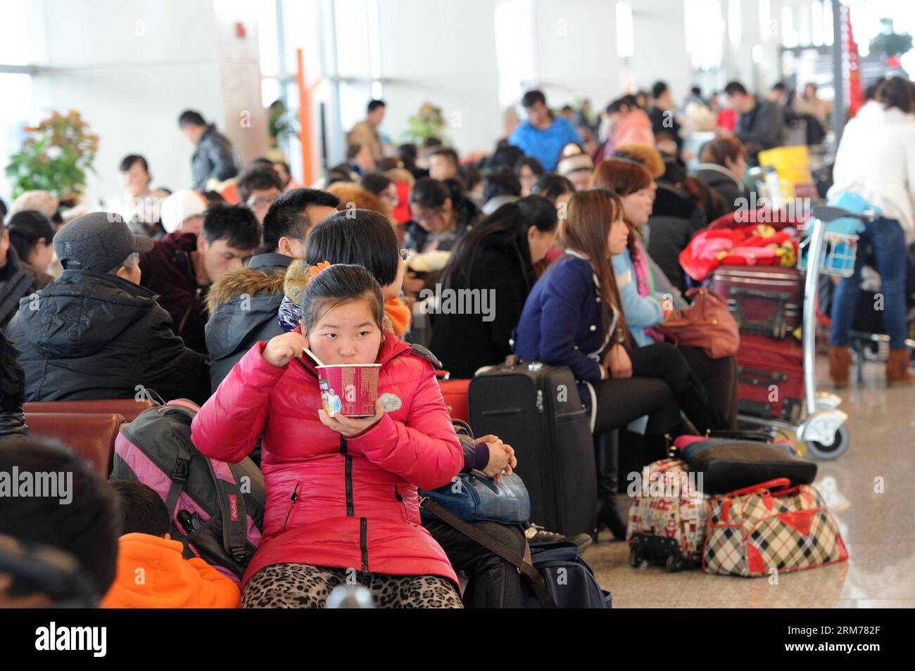 (140218) -- GUIYANG, Feb. 18, 2014 (Xinhua) -- A girl eats instant noodles when stranded at Longdongbao International Airport in Guiyang, capital of southwest China s Guizhou Province, Feb. 18, 2013. Heavy snow led to temporary closure of the airport at 8 a.m. Tuesday for snow and ice removal. More than 90 flights were canceled and over 4,800 passengers were affected before the airport was reopened at noon. (Xinhua/Tao Liang)(wjq) CHINA-GUIZHOU-SNOW-AIRPORT CLOSURE (CN) PUBLICATIONxNOTxINxCHN   Guiyang Feb 18 2014 XINHUA a Girl eats Instant Noodles When stranded AT Longdongbao International Ai Stock Photo