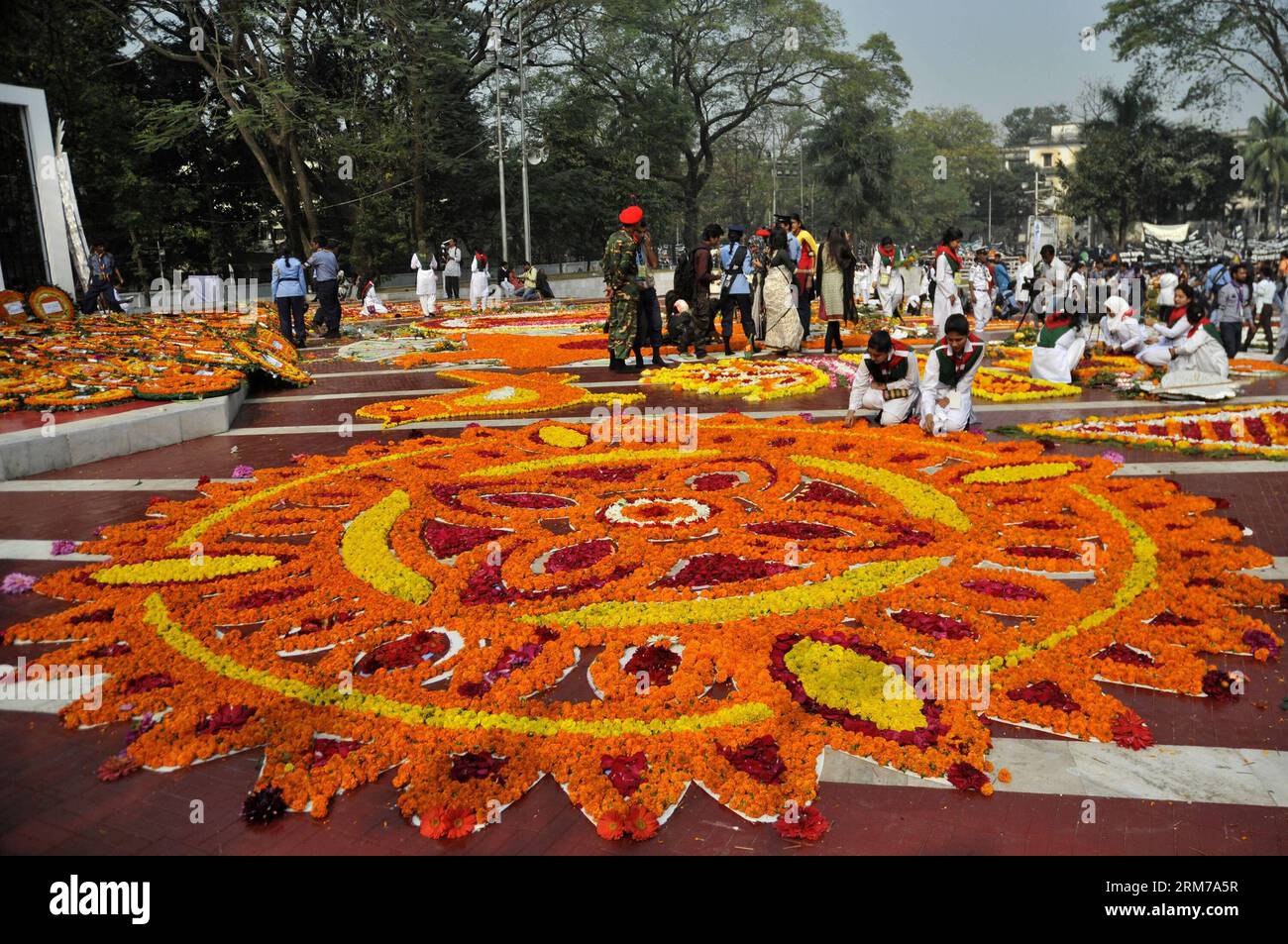 (140221) -- DHAKA, Feb. 21, 2014 (Xinhua) -- Volunteers decorate Language Martyrs Memorial monument with flowers during the International Mother Language Day in Dhaka, Bangladesh, Feb. 21, 2014. People pay tributes every year to the language movement martyrs, who sacrificed their lives for establishing Bangla as a state language of then Pakistan in 1952. United Nations Educational, Scientific and Cultural Organization declared Feb. 21 the International Mother Language Day on Nov. 17, 1999 to honor the supreme sacrifice of language martyrs. (Xinhua) BANGLADESH-DHAKA-MOTHER LANGUAGE DAY-CELEBRAT Stock Photo