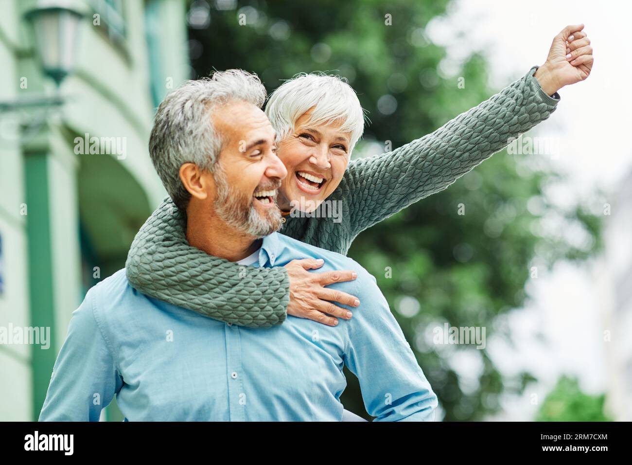 woman man outdoor senior couple happy lifestyle retirement together smiling love piggyback active mature Stock Photo