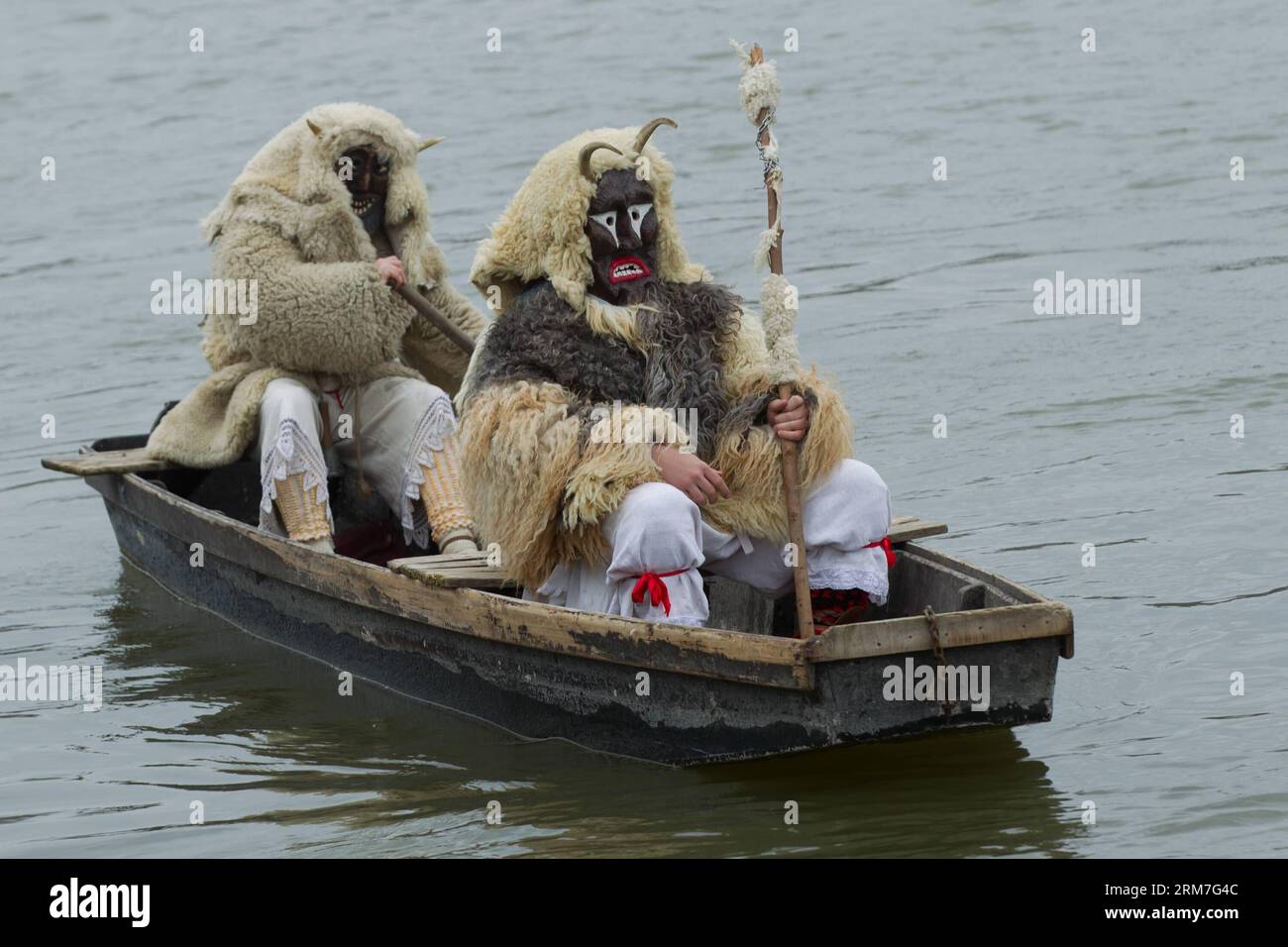 Masked busos (people wearing sheep fur and wooden masks) row across the Danube to celebrate the traditional Buso Carnival in Mohacs, southern Hungary on March 2, 2014. The Buso Carnival is an annual celebration of Sokac ethnic group living in Mohacs to bid farewell to winter and welcome spring. According to legend, local people dressed up in sheep fur and wooden masks in a bid to frighten off the Turkish invaders in the 16th century. This year s carnival takes place from February 27 till March 4. (Xinhua/Attila Volgyi) HUNGARY-MOHACS-BUSO CARNIVAL PUBLICATIONxNOTxINxCHN   Masked  Celebrities W Stock Photo