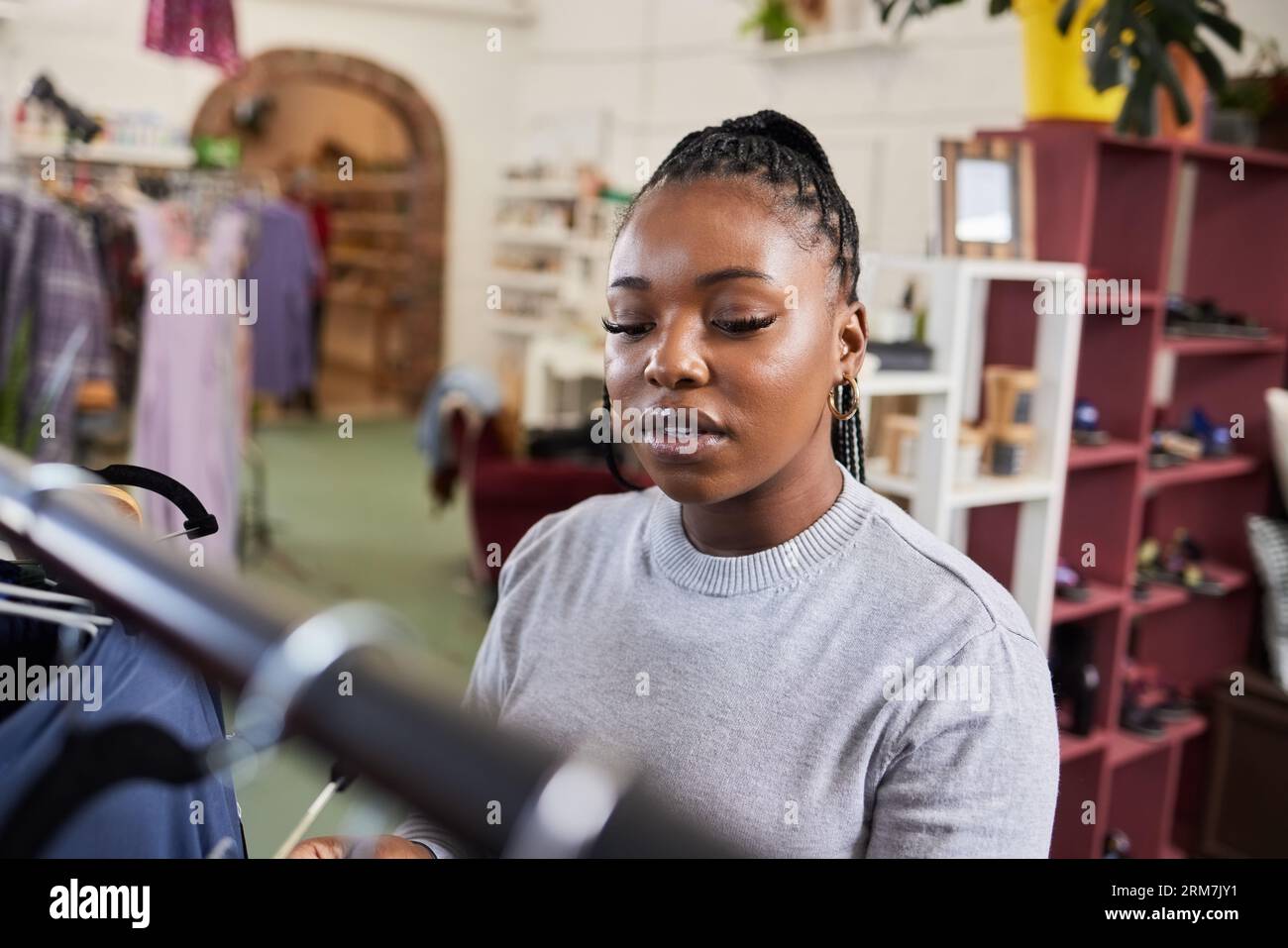 Shopping, woman and clothes rail for fashion at a retail store with sale or discount. A black person or customer in a shop for product choice Stock Photo