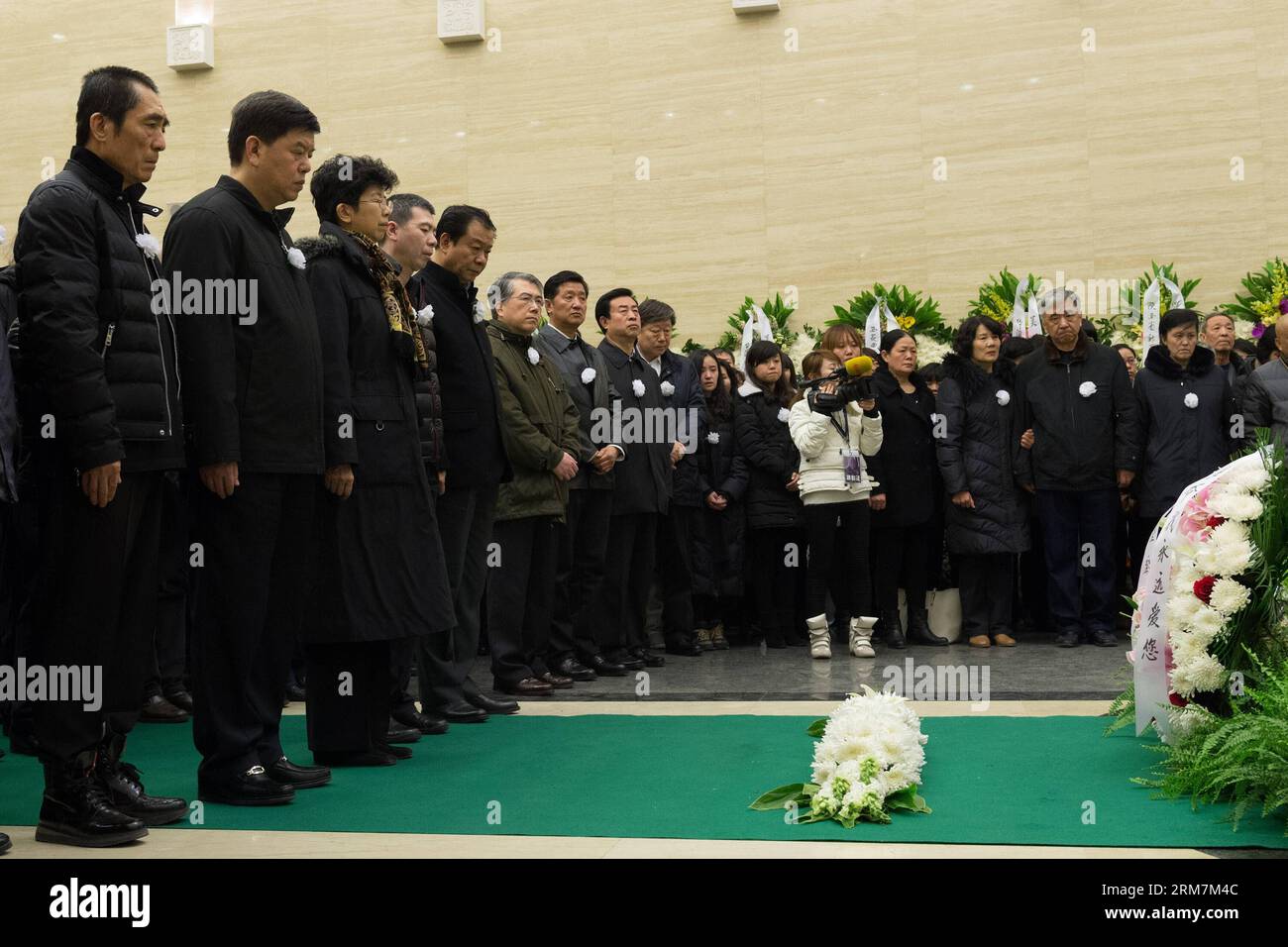 Film directors Zhang Yimou (1st L) and Feng Xiaogang (4th L) mourn for the late film director Wu Tianming at a memorial service held at the Babaoshan Funeral Home in Beijing, capital of China, March 8, 2014. Wu Tianming, who died of a heart attack on March 4 at the age of 75, was a leading figure of China s Fourth Generation film directors. While he was head of the renowned Xi an Film Studio, Wu spotted talents such as Zhang Yimou and Gu Changwei who later became representatives of China s Fifth Generation film directors. His major works include Old Well and Life . (Xinhua/Wu Kaixiang) (lmm) C Stock Photo