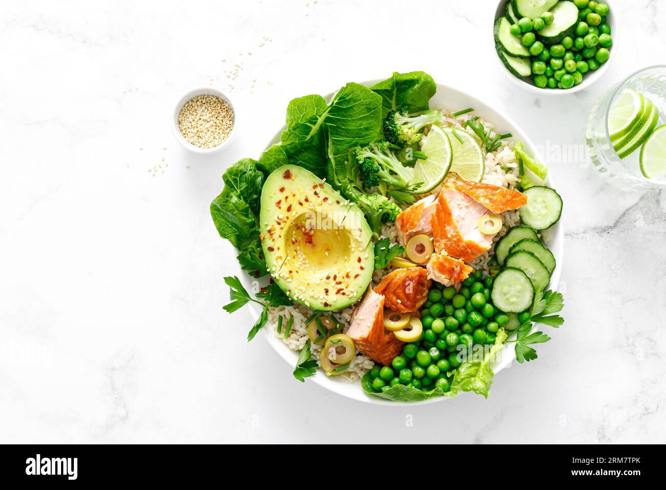 Salmon avocado bowl with broccoli, green peas, rice and fresh salad. Healthy food, top view Stock Photo