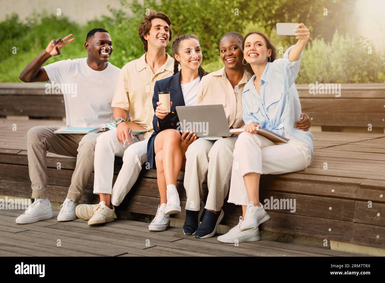 Diverse students taking selfie on smartphone at campus Stock Photo