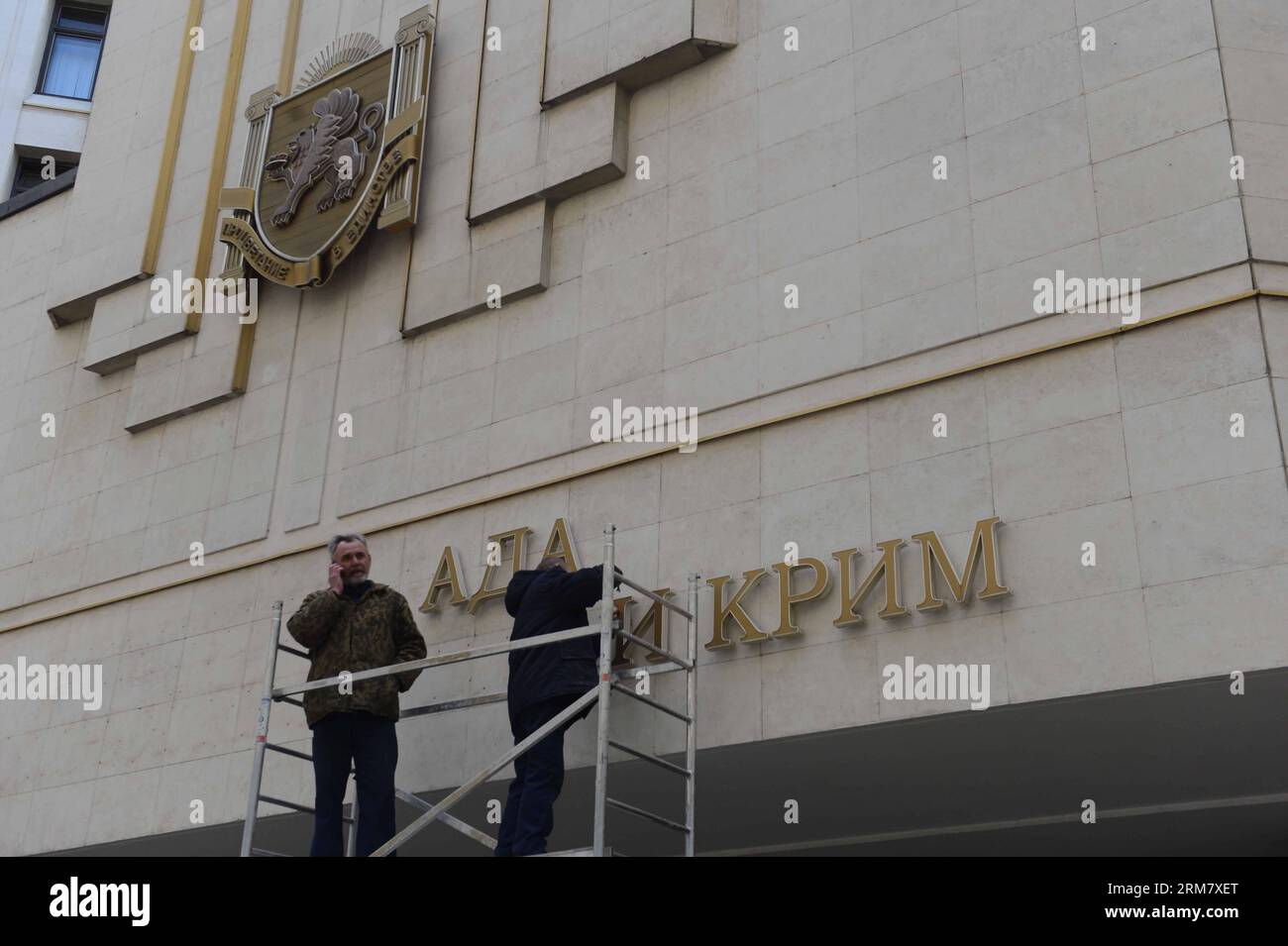 (140318) -- SIMFEROPOL, March 18, 2014 (Xinhua) -- Workers dismantle the Ukrainian signs on Crimean Parliament building in Simferopol, the Republic of Crimea, March 18, 2014. Russian President Vladimir Putin and leaders of Crimea signed a treaty on Tuesday accepting the Republic of Crimea and the city of Sevastopol as part of the Russian territory. (Xinhua/Sadat) (srb) CRIMEA-SIMFEROPOL-RUSSIA-TREATY PUBLICATIONxNOTxINxCHN Stock Photo