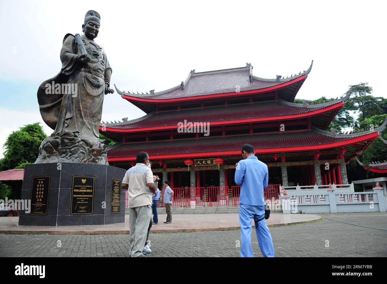 (140320) -- SEMARANG, March 20, 2014 (Xinhua) -- Tourist stand beside the statue of Chinese navy explorer Zheng He in front of the Sam Poo Kong Temple, in Semarang, Central Java, Indonesia, March 20, 2014. Chinese navy explorer Zheng He who visited the Central Java Province s port city of Semarang 600 years ago, built a mosque and set up a Chinese Muslim community in the city. The mosque was later turned into a temple by Semarang residents, now known as Sam Poo Kong with a huge Zheng He statue in its front. (Xinhua/Zulkarnain) (djj) INDONESIA-CENTRAL JAVA-SAM POO KONG TEMPLE PUBLICATIONxNOTxIN Stock Photo