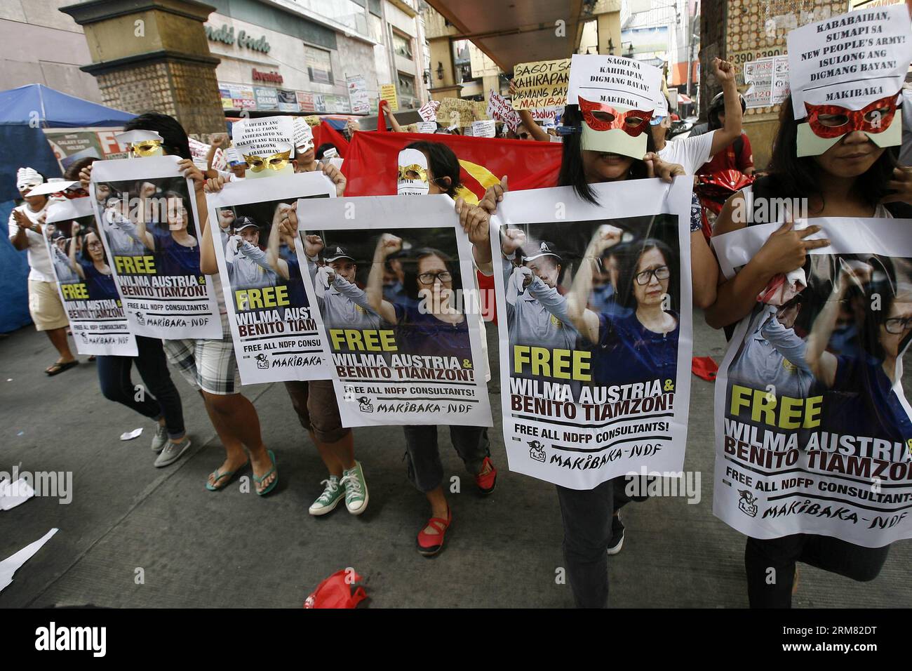 (140325) -- MANILA, March 25, 2014 (Xinhua) -- Members of the Communist Party of the Philippines and New People s Army (CPP-NPA) hold photos of Tiamzon couple during a rally in Manila, the Philippines, March 25, 2014. The political group condemned the arrest of CPP-NPA chairman Benito Tiamzon and his wife Wilma. (Xinhua/Rouelle Umali) PHILIPPINES-MANILA-CPP-NPA-RALLY PUBLICATIONxNOTxINxCHN   Manila March 25 2014 XINHUA Members of The Communist Party of The Philippines and New Celebrities S Army CPP NPA Hold Photos of  COUPLE during a Rally in Manila The Philippines March 25 2014 The Political Stock Photo