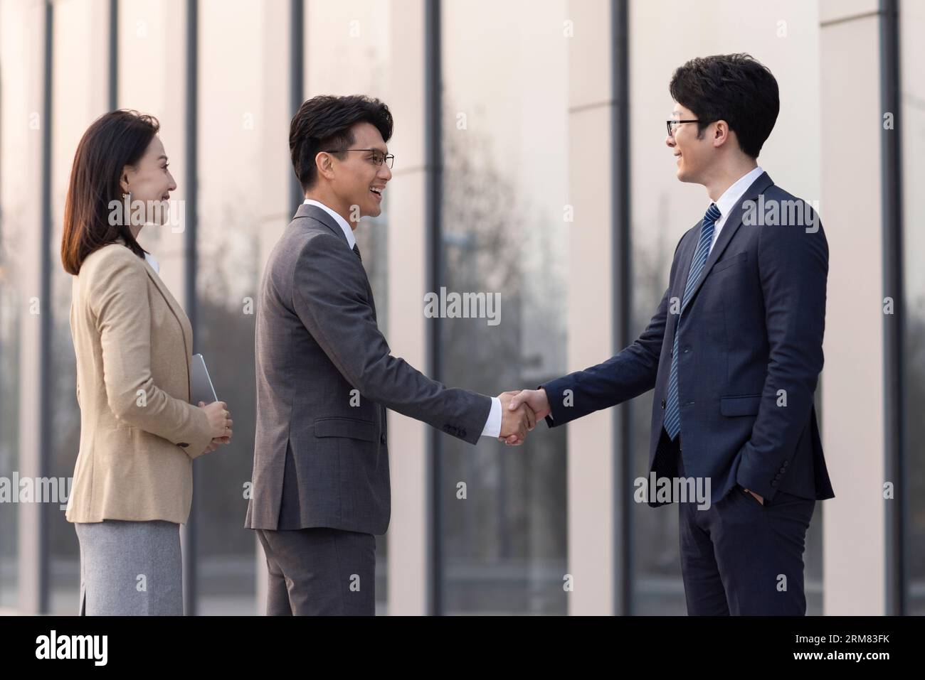 Confident business people shaking hands outdoors Stock Photo
