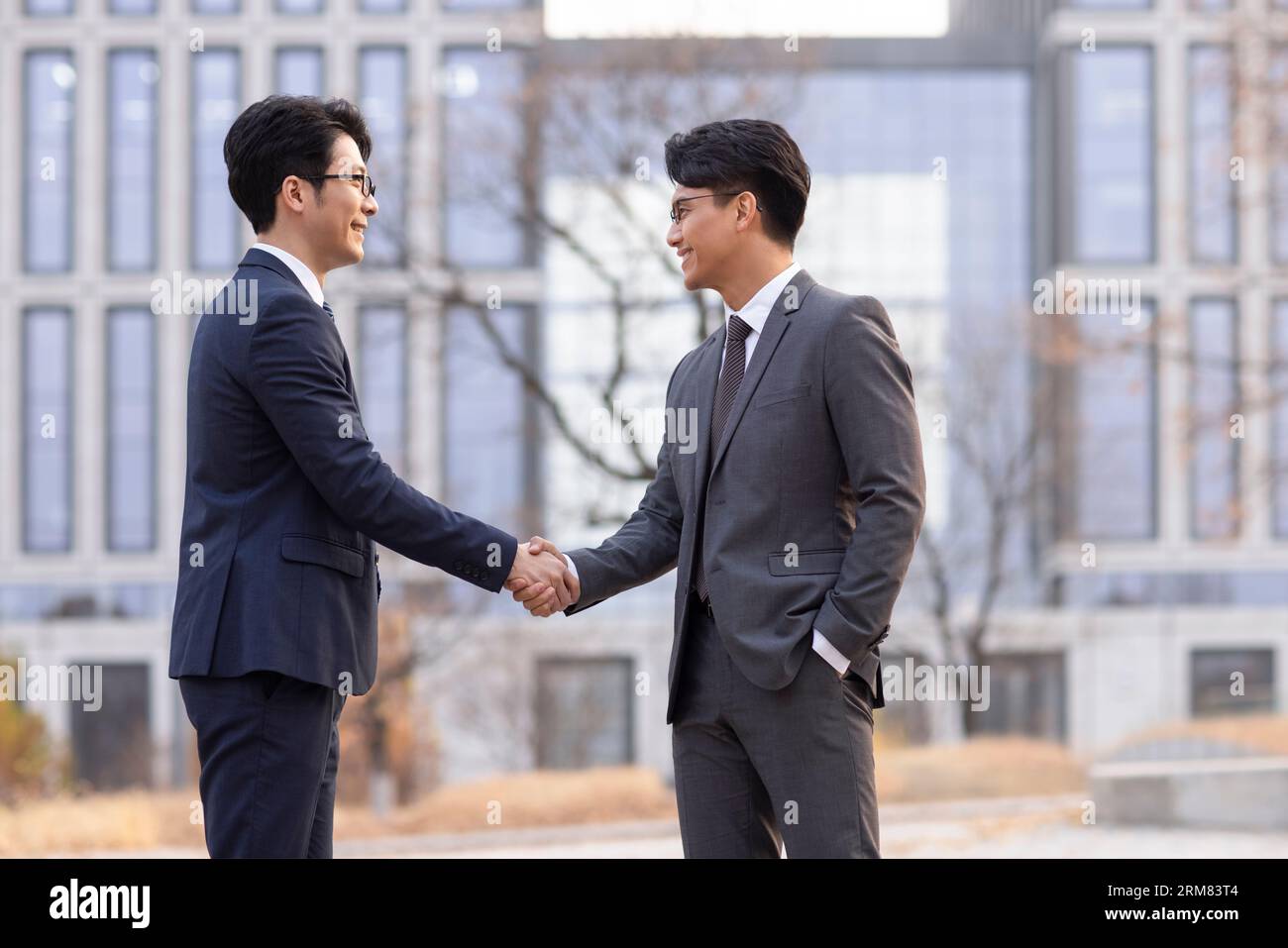 Confident businessmen shaking hands outdoors Stock Photo