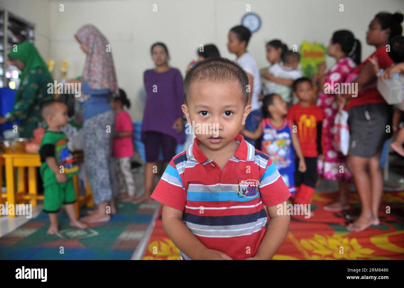 (140327) -- JAKARTA, March 27, 2014 (Xinhua) -- A boy poses for photos while people queue up at the health service center for children (Posyandu) at a slum area in Jakarta, Indonesia, March 27, 2014. (Xinhua/Agung Kuncahya B.) INDONESIA-JAKARTA-NUTRITION-CHILDREN PUBLICATIONxNOTxINxCHN   Jakarta March 27 2014 XINHUA a Boy Poses for Photos while Celebrities Queue up AT The Health Service Center for Children  AT a Slum Area in Jakarta Indonesia March 27 2014 XINHUA Agung Kuncahya B Indonesia Jakarta Nutrition Children PUBLICATIONxNOTxINxCHN Stock Photo
