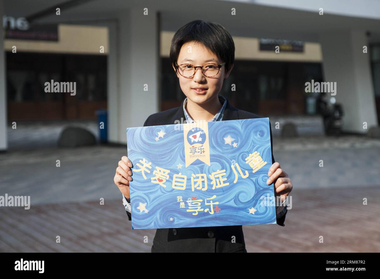 BEIJING,  2014 - Yi Yuxi, a junior high school student volunteer for autistic children, holds a placard reading care for autistic children in Beijing, capital of China, March 15, 2014. The World Autism Awareness Day falls on April 2, drawing attention to the pervasive developmental disorder that affects tens of millions of children around the globe. Xinhua/Zhang Keren wf CHINA-BEIJING-WORLD AUTISOM AWARENESS DAY-VOLUNTEER CN PUBLICATIONxNOTxINxCHN Stock Photo