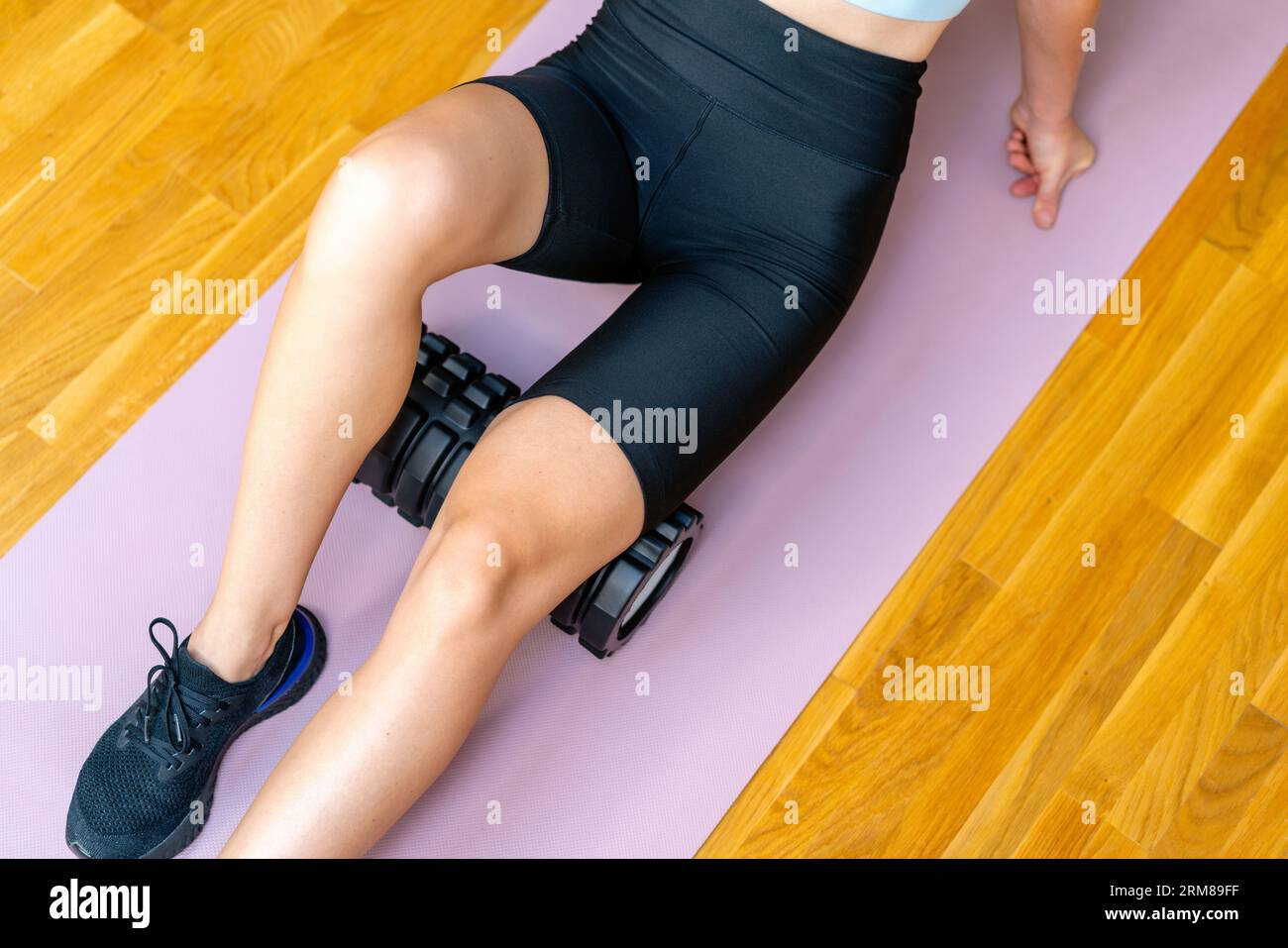 sports woman doing warmup exercise for muscles of legs before fitness