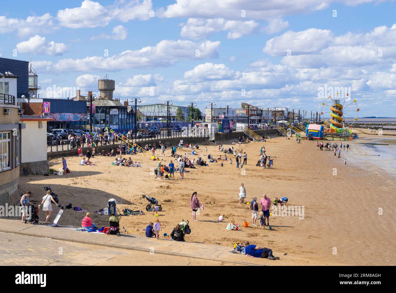 Busy beach at Cleethorpes Beach with Cleethorpes Fun Fair on the sands at Cleethorpes Lincolnshire England UK GB Europe Stock Photo