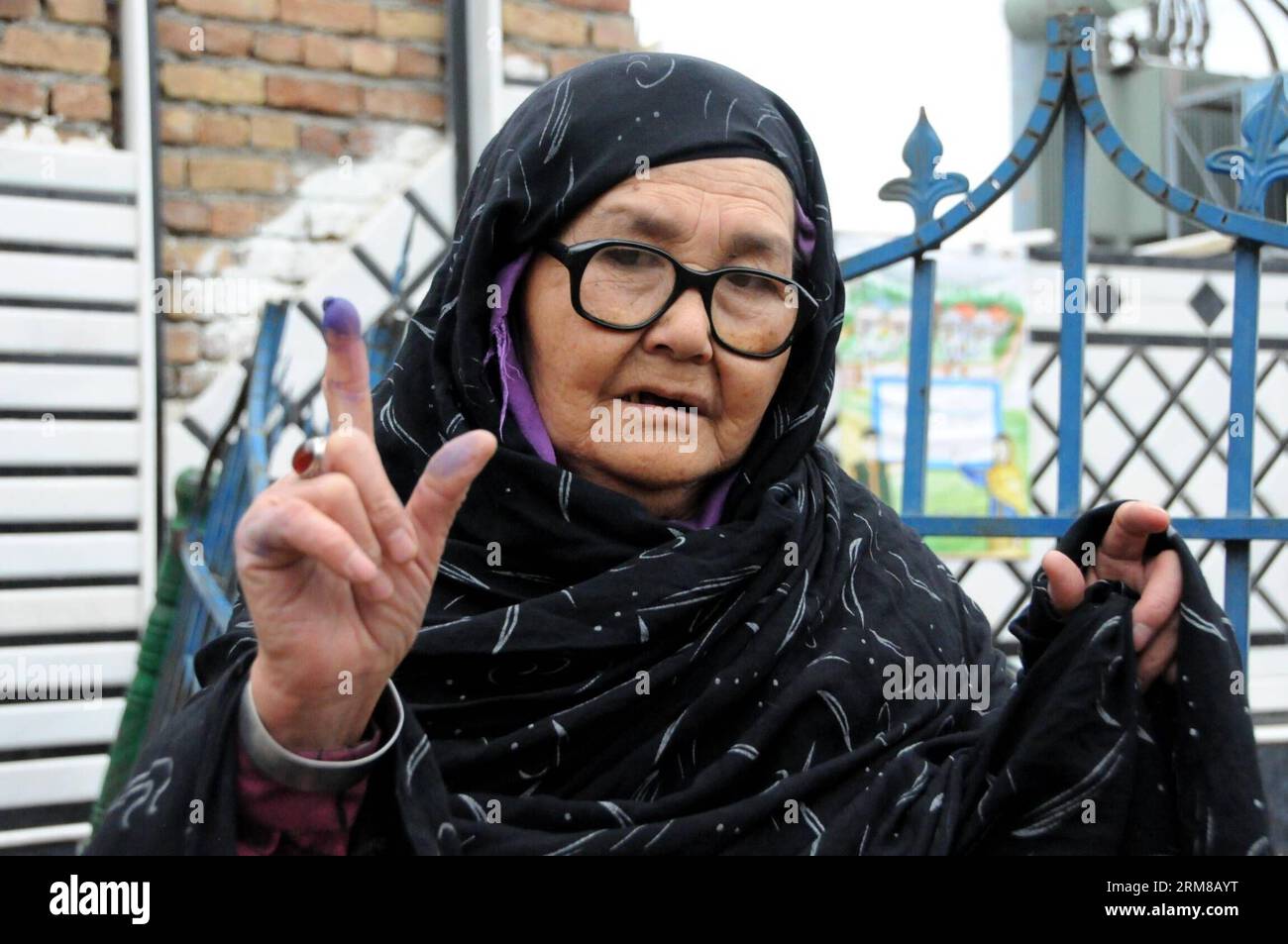 An Afghan woman shows her inked finger after casting her ballot at a polling center in Kabul, Afghanistan, on April 5, 2014. The polling for Afghanistan s presidential election concluded on Saturday and counting of ballots has begun, the country s election officials said. A total of 6,218 polling centers remained open on the election day and around 7 million eligible voters, 36 percent of them women, had cast their votes. (Xinhua/Omid) AFGHANISTAN-PRESIDENTIAL ELECTION-BALLOTING-CONCLUSION PUBLICATIONxNOTxINxCHN   to Afghan Woman Shows her inked Fingers After Casting her Ballot AT a Polling Ce Stock Photo