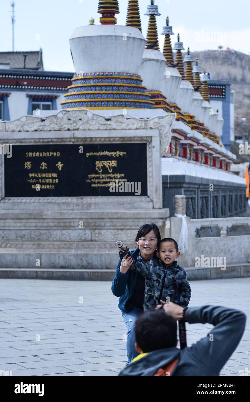 (140406) -- HUANGZHONG COUNTY, April 6, 2014 (Xinhua) -- Two tourists pose for photos in the Kumbum Monastery in Huangzhong County of Xining, capital of northwest China s Qinghai Province, April 6, 2014. The Kumbum Monastery is a main destination for Tibetan Buddhist pilgrims. It is also a major tourist attraction in Qinghai, which features splendid religious murals, Thangka appliques and butter sculptures. (Xinhua/Wu Gang) (lmm) CHINA-QINGHAI-KUMBUM MONASTERY-TOURISM (CN) PUBLICATIONxNOTxINxCHN   Huang Zhong County April 6 2014 XINHUA Two tourists Pose for Photos in The Kumbum monastery in Hu Stock Photo