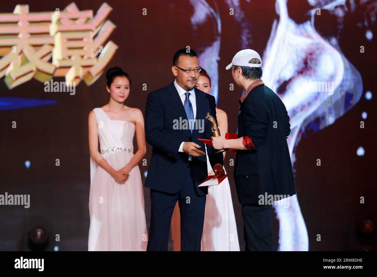 Director Jiang Wen gives an award to singer Cui Jian (R Front) at the 2013 annual commendation conference of China Film Directors Guild in Beijing, capital of China, April 9, 2014. (Xinhua) (zwy) CHINA-BEIJING-COMMENDATION CONFERENCE-CHINA FILM DIRECTORS GUILD(CN) PUBLICATIONxNOTxINxCHN   Director Jiang Wen Gives to Award to Singer Cui Jian r Front AT The 2013 Annual  Conference of China Film Directors Guild in Beijing Capital of China April 9 2014 XINHUA  China Beijing  Conference China Film Directors Guild CN PUBLICATIONxNOTxINxCHN Stock Photo