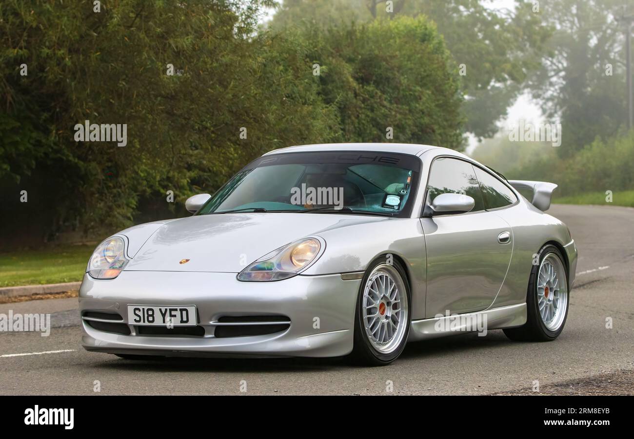 Whittlebury,Northants,UK -Aug 26th 2023: 1998 silver Porsche 911 Carrera car travelling on an English country road on a damp and misty morning. Stock Photo