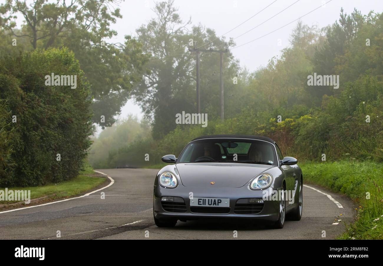 Whittlebury,Northants,UK -Aug 26th 2023: 2007 grey Porsche Boxster car travelling on an English country road on a damp and misty morning. Stock Photo