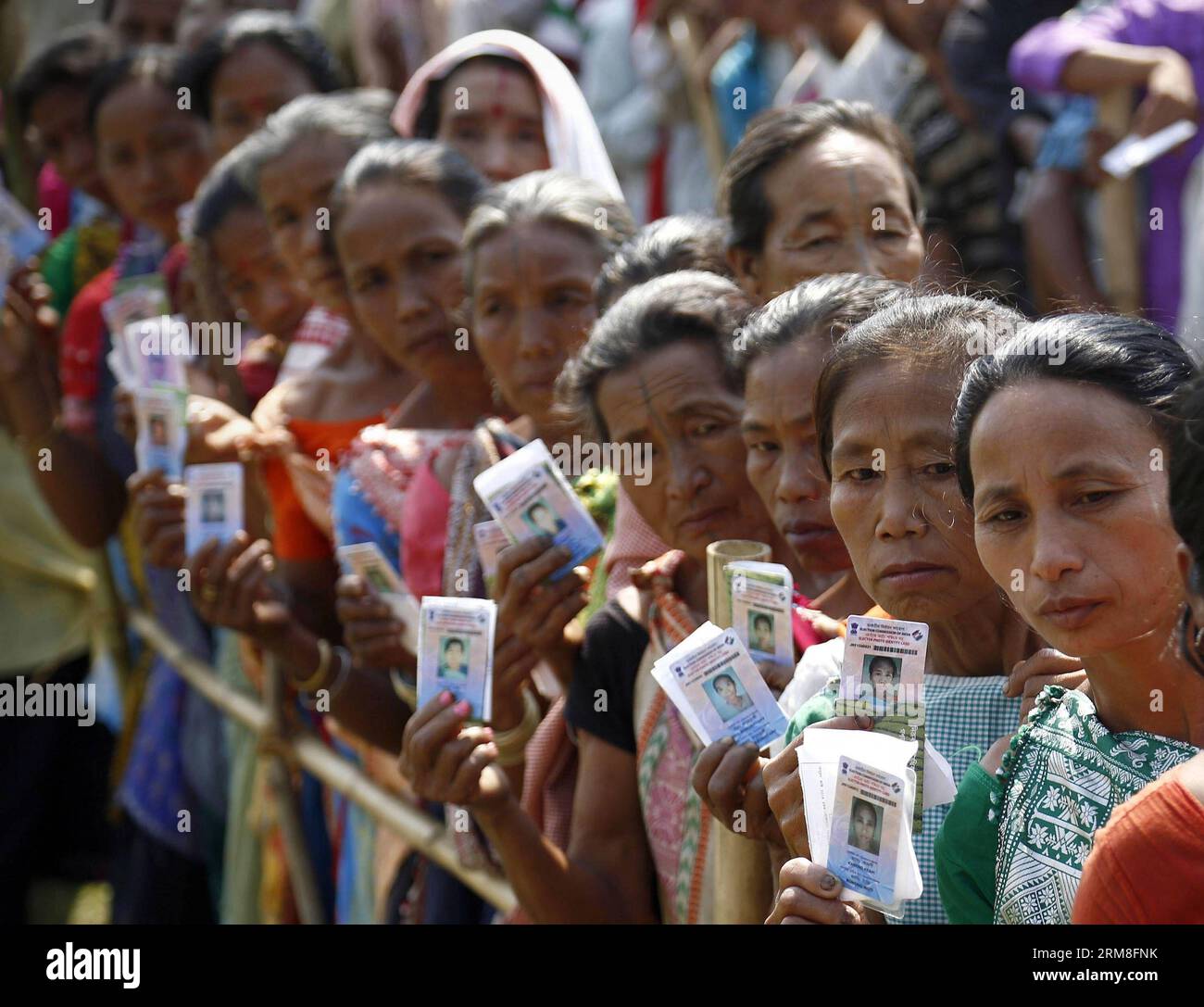 (140412) -- DIPHU, April 12, 2014 (Xinhua) -- People wait in queue and show their voter identity cards at a polling booth in Diphu, in the northeastern Indian state of Assam, April 12, 2014. The multi-phase voting across the country runs until May 12, with results for the 543-seat lower house of parliament to be announced on May 16. (Xinhua/Stringer) INDIA-DIPHU-ELECTION PUBLICATIONxNOTxINxCHN   April 12 2014 XINHUA Celebrities Wait in Queue and Show their Voter Identity Cards AT a Polling Booth in  in The Northeastern Indian State of Assam April 12 2014 The Multi Phase Voting across The Count Stock Photo