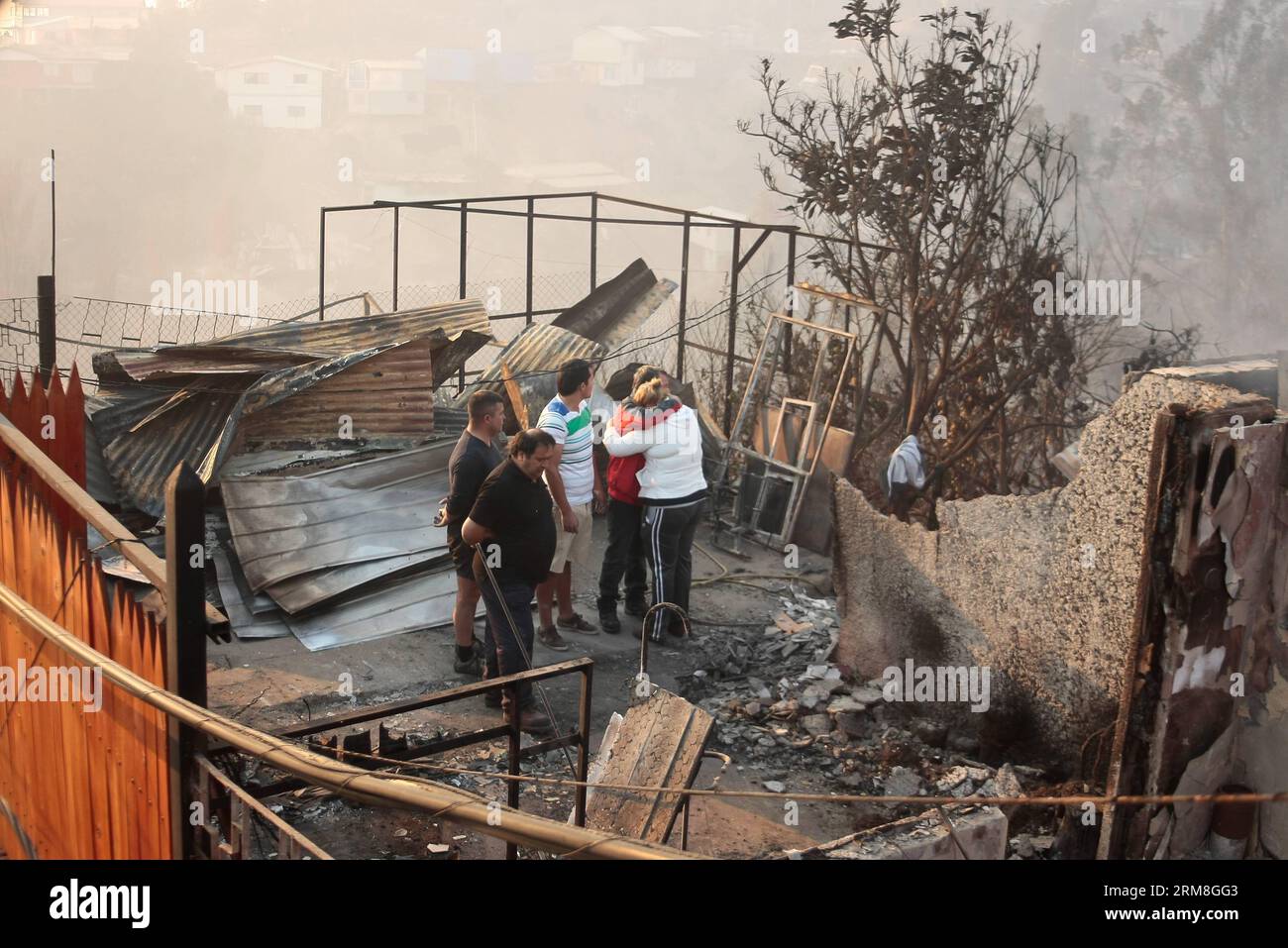 Residents stand next to their houses destroyed by a fire in Valparaiso, Chile on April 13, 2014. At least 11 people were killed over the weekend in a massive forest fire that broke out in Chile s port city of Valparaiso, authorities said Sunday. President Michelle Bachelet declared state of emergency in the city and sent the army in to maintain order as thousands of residents were evacuated. (Xinhua/Pablo Ovalle/AGENCIA UNO) CHILE-VALPARAISO-FIRE PUBLICATIONxNOTxINxCHN   Residents stand Next to their Houses destroyed by a Fire in Valparaiso Chile ON April 13 2014 AT least 11 Celebrities Were K Stock Photo