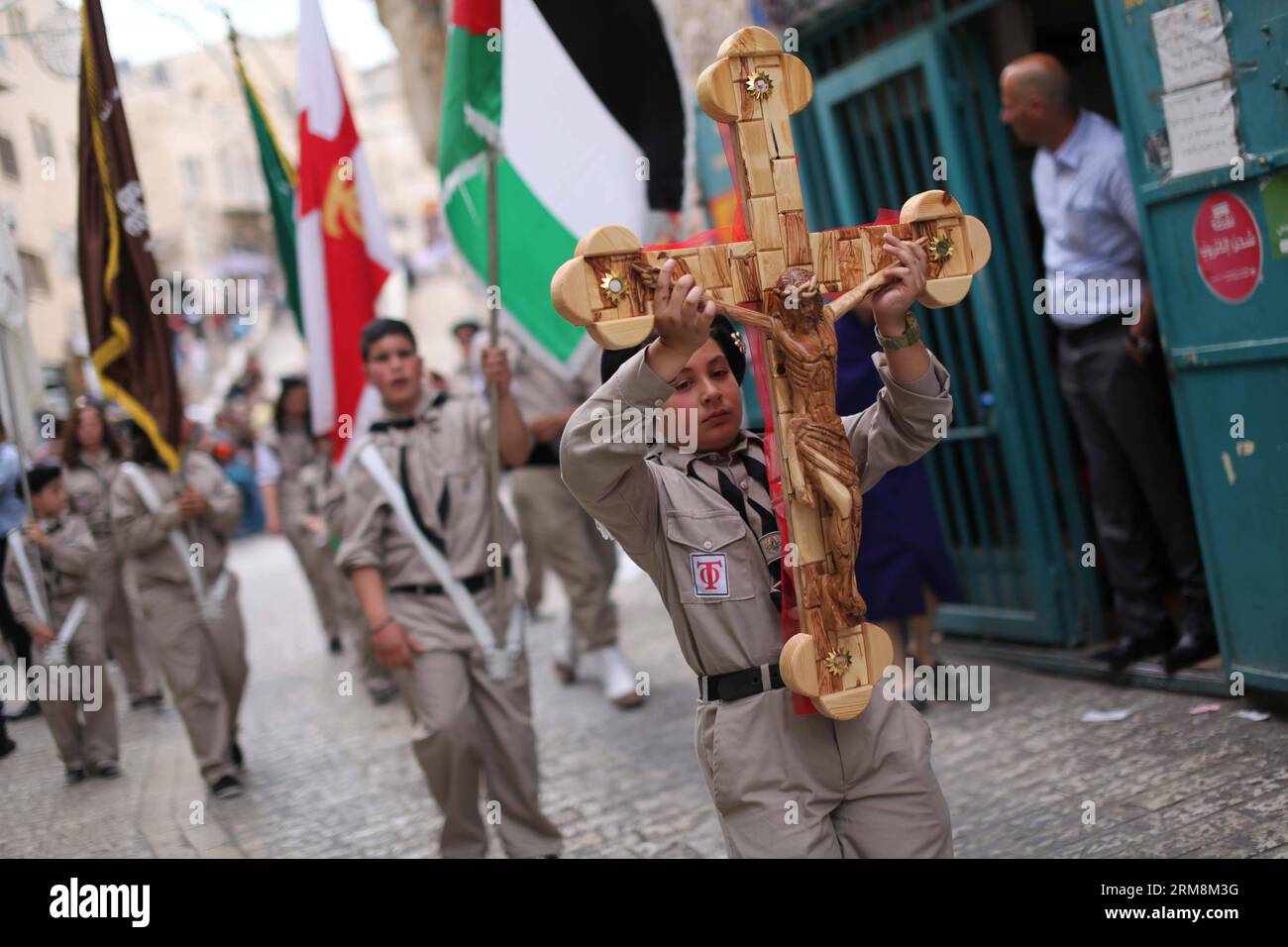 (140420) -- BETHLEHEM, April 20, 2014 (Xinhua) - Palestinian scouts perform as they take part in the ceremony of the Holy Fire outside the Church of the Nativity, which is built over the traditional site of Jesus birth in Bethlehem, April 19, 2014. During the annual ceremony, top clerics enter the Aedicule, the small chamber marking the site of Jesus tomb at the Church of the Holy Sepulcher Jerusalem, traditionally believed to be the burial site of Jesus Christ. They emerge after to reveal candles lit with Holy Fire said to be miraculously lit as a message to the faithful from heaven. The deta Stock Photo