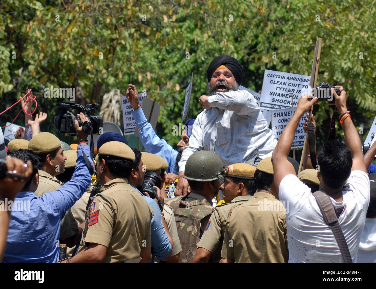 (140421) -- NEW DELHI, April 21, 2014 (Xinhua) -- Indian Sikh protesters shout slogans near a police barricade during a protest against Congress party leader and former chief minister of Punjab state Amarinder Singh for his recent remarks on the country s 1984 anti-Sikh riots in New Delhi, India, April 21, 2014. Singh in a recent television interview said party leader Jagdish Tytler, one of the accused, had no role in the 1984 riots that killed more than 3,000 Sikhs. Top Congress party leaders have been accused of inciting mobs during the violence that followed the assassination of Prime Minis Stock Photo