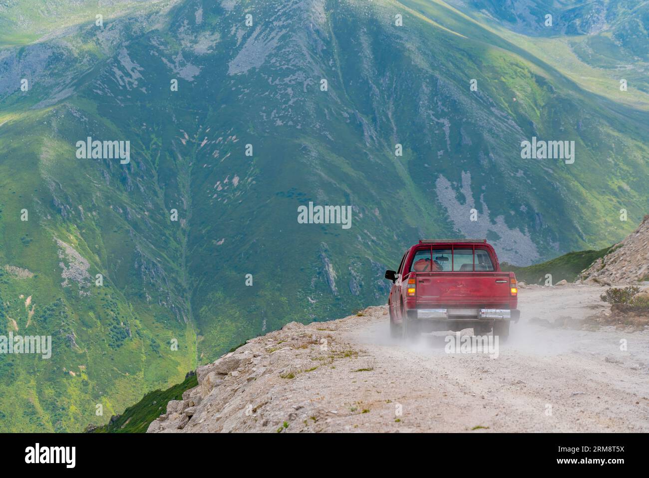 A red pickup truck driving on dirt roads on high plateau roads in Turkey Stock Photo