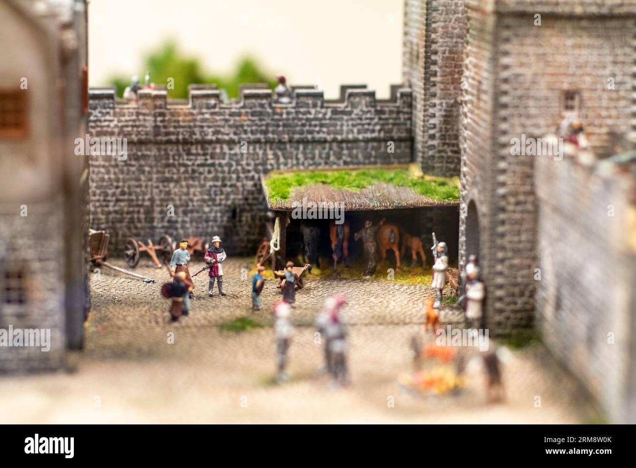 Miniature diorama at Miniatur Wunderland in Hamburg, Germany, depicting a historical scene with people going about their daily lives inside a castle Stock Photo