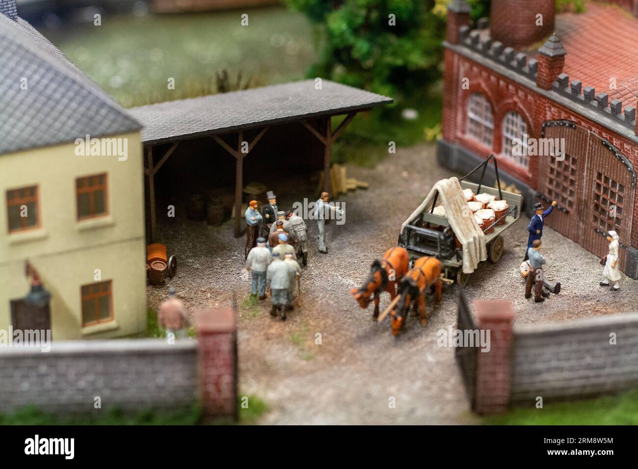 Miniature diorama at Miniatur Wunderland in Hamburg, Germany, depicting a historical scene with horse-drawn cart and people outside a factory Stock Photo