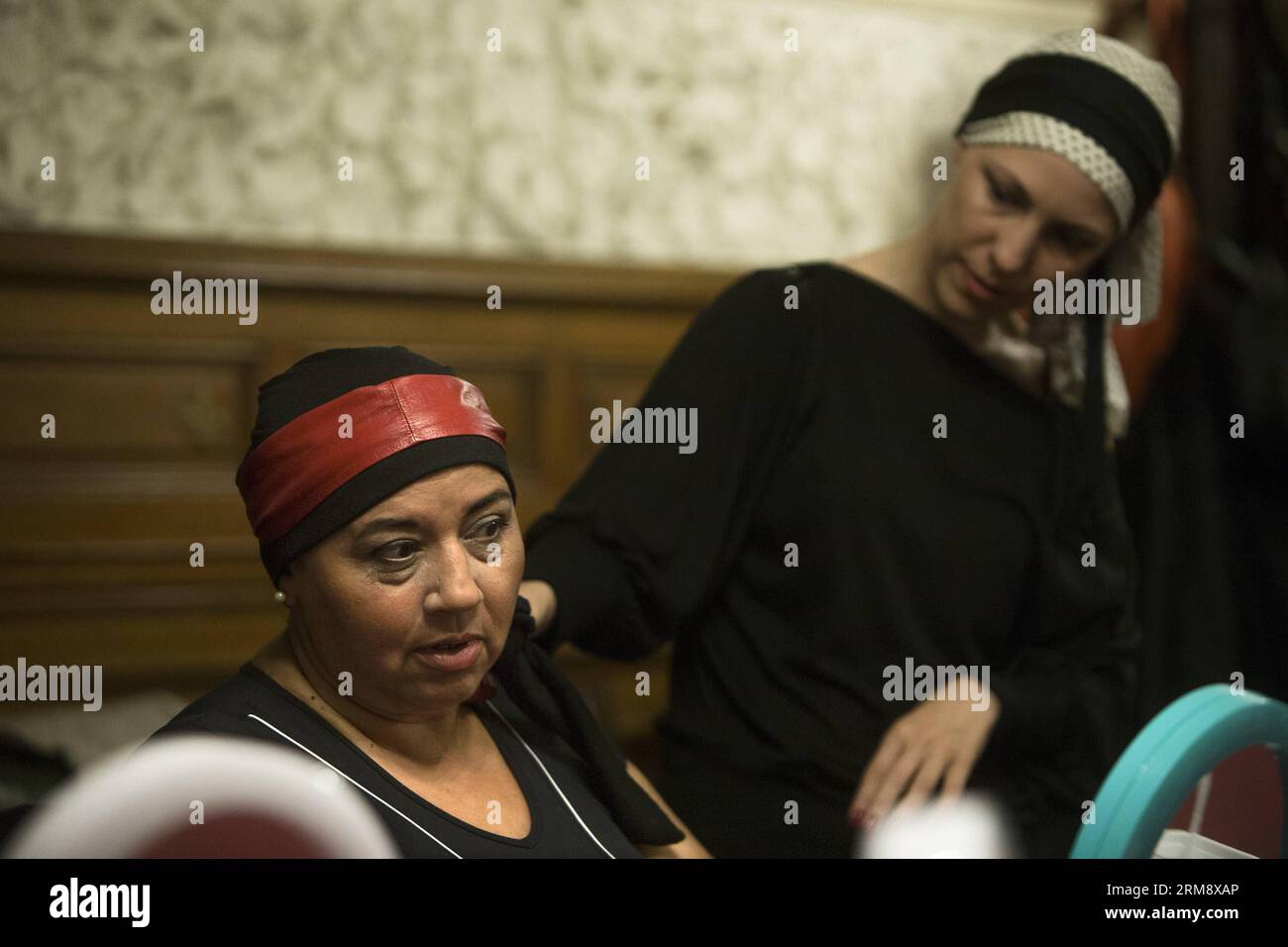 BUENOS AIRES, April 22, 2014 (Xinhua) -- Image taken on April 22, 2014,  shows Maria Cristina Alanis (L) watching her turban designed by volunteer  Paola (R) in a make up class during