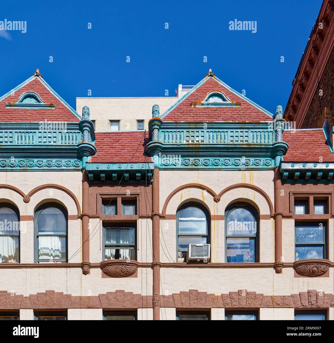 Upper West Side: A fanciful tile roofline fronts the flat roofs of 331 & 329 West 85th Street, landmark Queen Anne-styled row houses built in 1891. Stock Photo