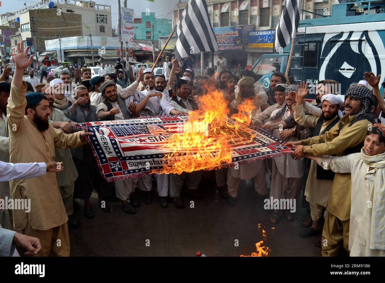Pakistani protester burn a US flag as they shout slogans during a protest on the third anniversary of the death of slain Al-Qaeda leader Osama bin Laden, in southwest Pakistan s Quetta on May 2, 2014. Osama bin Laden was killed by U.S. military force on May 2, 2011, in a fortress-like compound on the outskirts of Pakistani city of Abbottabad. (Xinhua/Asad) (WORLD SECTION) PAKISTAN-QUETTA-BIN LADEN-PROTEST PUBLICATIONxNOTxINxCHN   Pakistani  Burn a U.S. Flag As They Shout Slogans during a Protest ON The Third Anniversary of The Death of Slain Al Qaeda Leader Osama am shop in Southwest Pakistan Stock Photo