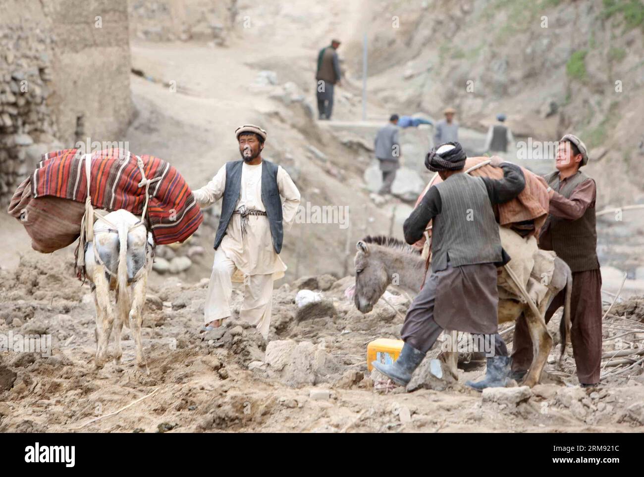 (140504) -- BADAKHSHAN,  (Xinhua) -- Afghan men and their donkeys are seen at the landslide site in Badakhshan, Afghanistan, May 3, 2014. A massive landslide hit a village in northern Afghan Badakhshan province on Friday, causing heavy casualties, but the exact number of deaths and injuries remained unknown Saturday as officials here released contradictory numbers. (Xinhua/Ahmad Massoud) AFGHNAISTAN-BADAKHSHAN-LANDSLIDE PUBLICATIONxNOTxINxCHN   Badakhshan XINHUA Afghan Men and their Donkeys are Lakes AT The landslide Site in Badakhshan Afghanistan May 3 2014 a Massive landslide Hit a Village i Stock Photo