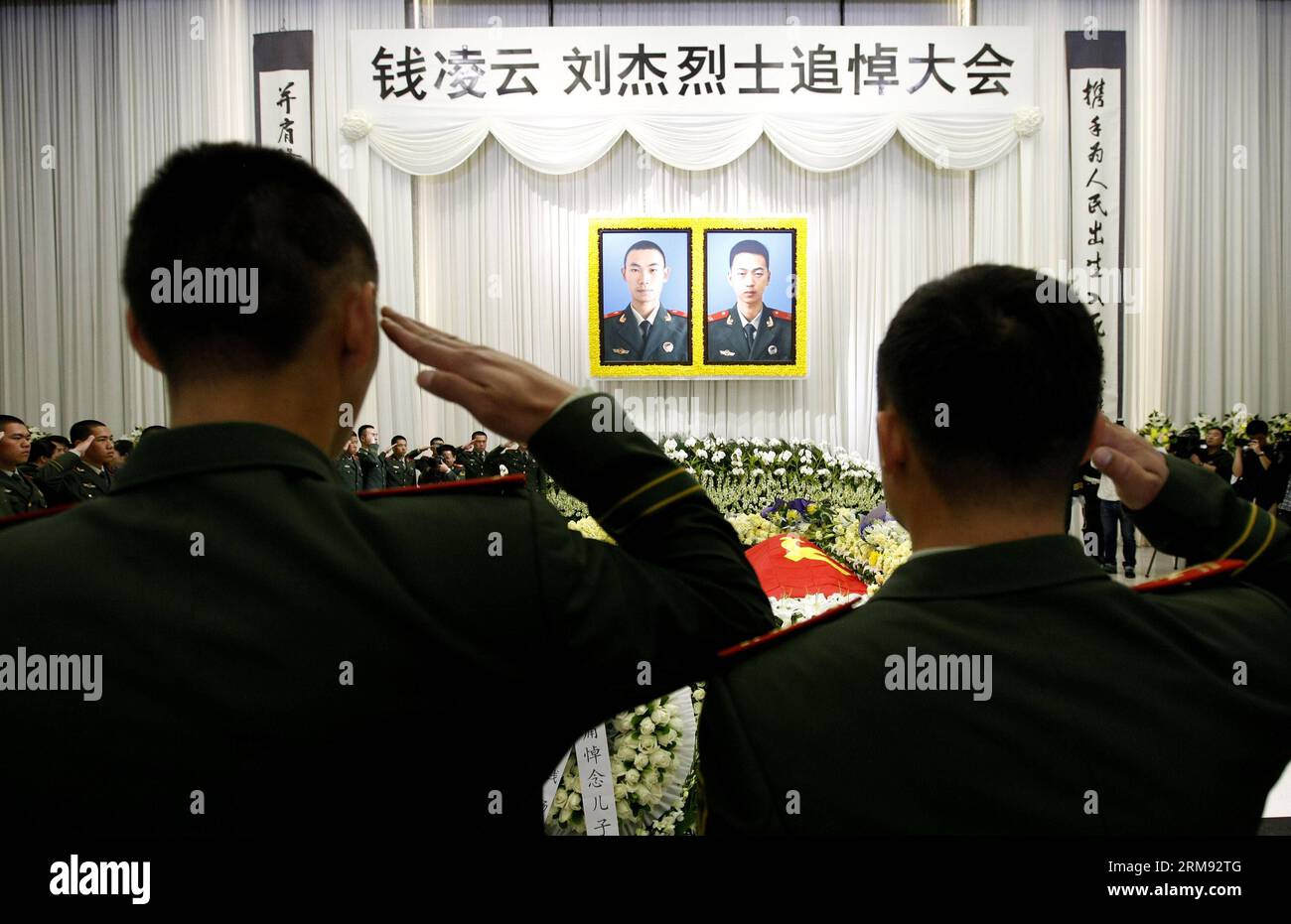 (140505) -- SHANGHAI, May 5, 2014 (Xinhua) -- Firefighters salute as they mourn for Qian Lingyun and Liu Jie, two young Chinese firefighters who fell to their death during a blaze in a highrise building, at a memorial meeting in Shanghai, east China, May 5, 2014. Qian Lingyun and Liu Jie, who were born in 1991 and 1994 respectively, died on May 3 while responding to the fire in an apartment on the 13th floor of the building where a sudden blast occurred and the force blew them through an open window. (Xinhua/Fang Zhe) (lfj) CHINA-SHANGHAI-YOUNG FIREFIGHTERS-MOURNING (CN) PUBLICATIONxNOTxINxCHN Stock Photo