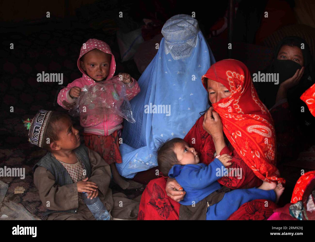 (140505) -- BADAKHSHAN, May 4, 2014 (Xinhua) -- Afghan women with their children sit under a tent waiting for relief food after a landside in Badakhshan province, northern Afghanistan, May 4, 2014. The deadly landslide occurred Friday in the mountainous province of Badakhshan. Although there is no official death toll, provincial governor Shah Waliullah Adeeb told Xinhua that more than 2,500 people might have lost their lives. (Xinhua/Ahmad Massoud) AFGHANISTAN-BADAKHSHAN-LANDSLIDE PUBLICATIONxNOTxINxCHN   Badakhshan May 4 2014 XINHUA Afghan Women With their Children Sit Under a Tent Waiting fo Stock Photo