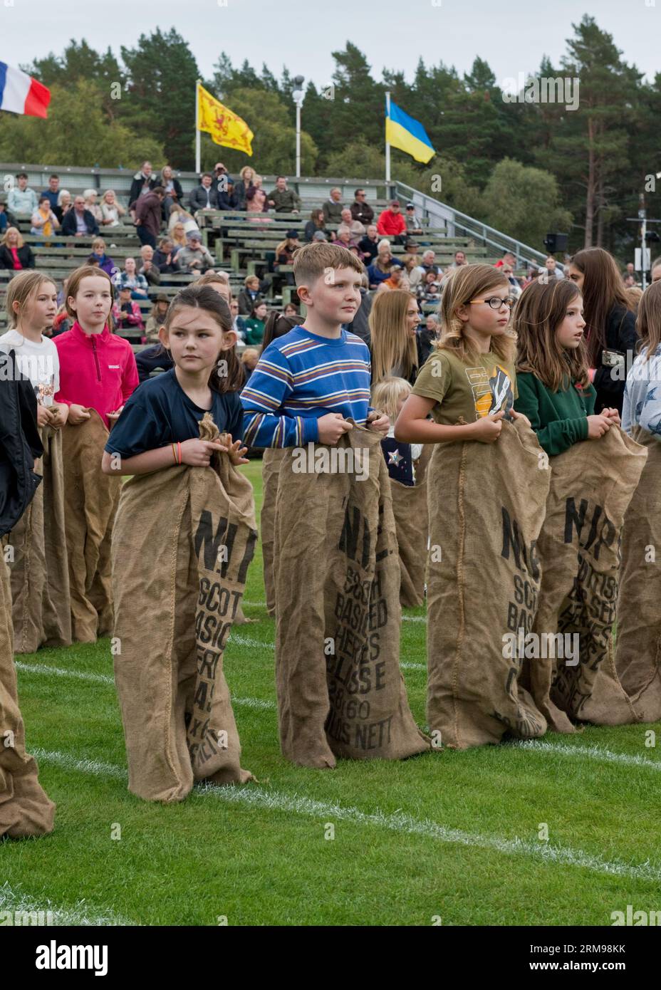 Children lined up waiting for start of their sack race at the Braemar Gathering, Highland Games. Aberdeenshire, Scotland Stock Photo