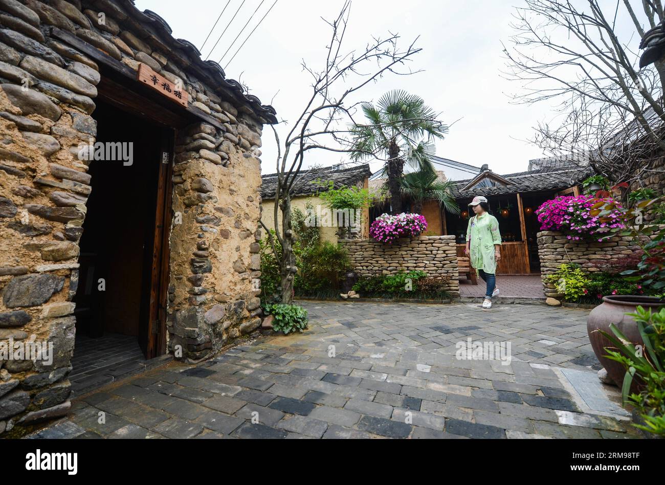 (140513) -- TONGLU, May 13, 2014 (Xinhua) -- A tourist visit the swinery tea bar in Dipu Village of Jiangnan Town in Tonglu County, east China s Zhejiang Province, May 13, 2014. Dipu Village, a national historical and cultural village with nearly a thousand years history, has committed to environment reform, village protection and tourism development for the past few years. The swinery tea bar sets a successful example of the transform. The bar used to be five messy stone houses for pigs keeping. After renovation, it functions as a modern tea bar with traditional appearance, attracting many to Stock Photo