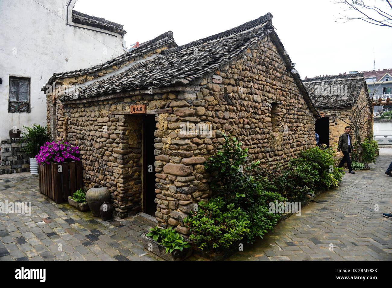 (140513) -- TONGLU, May 13, 2014 (Xinhua) -- Photo taken on May 13, 2014 shows the swinery tea bar in Dipu Village of Jiangnan Town in Tonglu County, east China s Zhejiang Province. Dipu Village, a national historical and cultural village with nearly a thousand years history, has committed to environment reform, village protection and tourism development for the past few years. The swinery tea bar sets a successful example of the transform. The bar used to be five messy stone houses for pigs keeping. After renovation, it functions as a modern tea bar with traditional appearance, attracting man Stock Photo