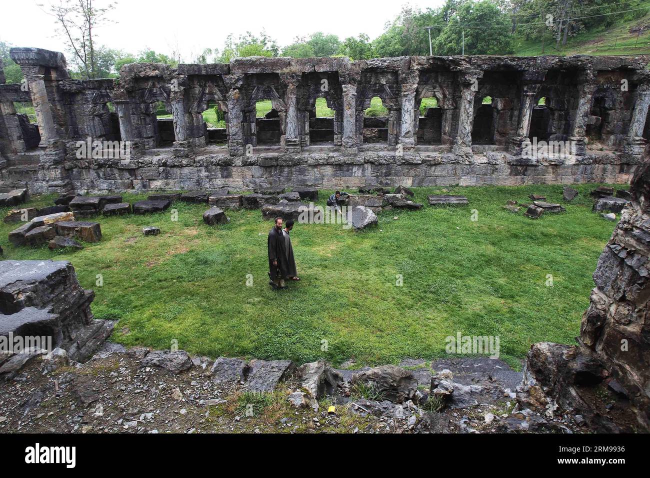 SRINAGAR, May 12, 2014 - Two Kashmiri men walk near the ruins of ...