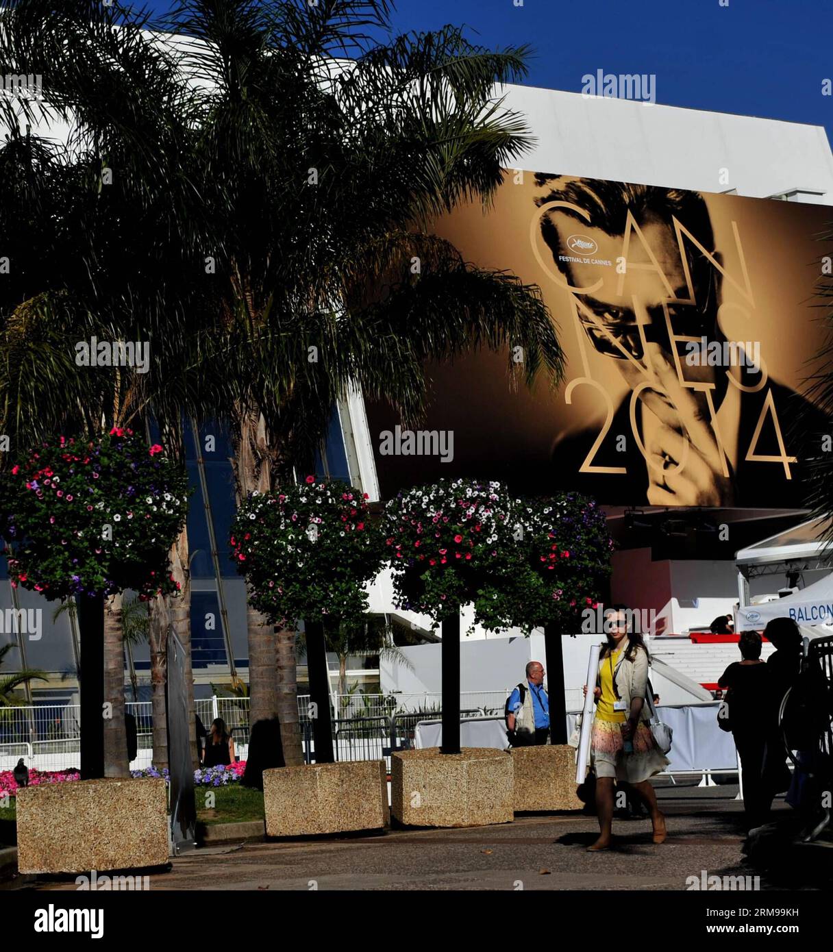 (140514) -- CANNES, May 14, 2014 (Xinhua) -- People walk past a giant poster of the 67th Cannes Film Festival in Cannes, France, May 14, 2014. The 67th Cannes Film Festival will run from May 14 to 24 with 18 films competing for the top prize the Palme d Or. (Xinhua/Chen Xiaowei) FRANCE-CANNES-ENTERTAINMENT-67TH CANNES FILM FESTIVAL PUBLICATIONxNOTxINxCHN   Cannes May 14 2014 XINHUA Celebrities Walk Past a Giant Poster of The 67th Cannes Film Festival in Cannes France May 14 2014 The 67th Cannes Film Festival will Run from May 14 to 24 With 18 Films competing for The Top Prize The Palme D or XI Stock Photo