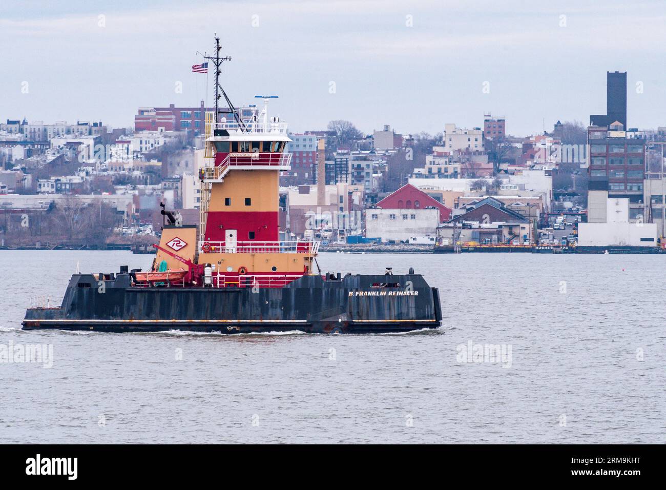 A tugboat in New York Harbor with Brooklyn in the background Stock Photo