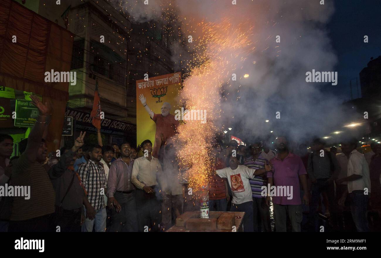 CALCUTTA, May 26, 2014 - Supporters of Indian Bharatiya Janata Party (BJP) light fire crackers after the oath taking ceremony of Narendra Modi as India s 15th prime minister in Calcutta, capital of eastern Indian state West Bengal, May 26, 2014. Narendra Modi, the son of a tea-seller, on Monday created history by becoming Indian new prime minister in a grand ceremony attended by his counterpart from arch- rival Pakistan, along with heads of state of other South Asian nations. (Xinhua/Tumpa Mondal) INDIA-CALCUTTA-MODI-CEREMONY PUBLICATIONxNOTxINxCHN   Calcutta May 26 2014 Supporters of Indian B Stock Photo