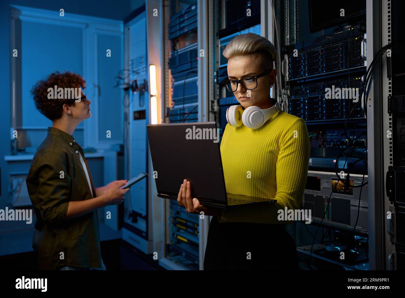 Serious technicians working together with network hardware Stock Photo