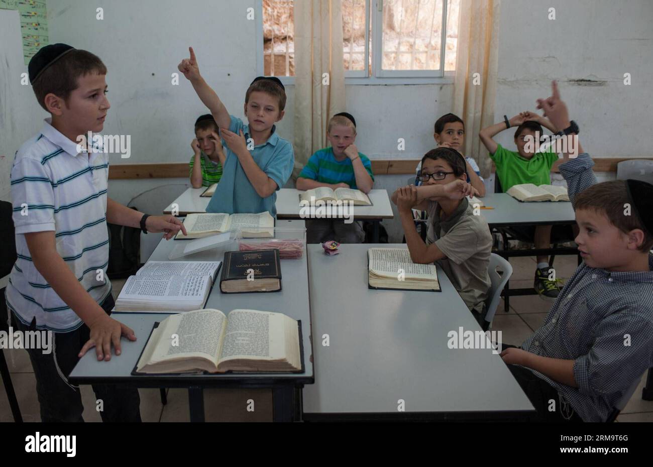 Tzviel Noyman (1st L) asks a question when leading a class of Jewish religion at Torat Moshe elementary school in Beit Shemesh, about 20 km from Jerusalem, on May 29, 2014. Tzviel Noyman is an Israeli Ultra-Orthodox boy in a family with six children, three boys and three girls. He is ten years old this year and a grade three pupil of Torat Moshe elementary school, which is only opened to Jewish children. Tzviel has eight classes each day, including Hebrew, English, mathematics and Jewish religion, which has four classes each day including Talmud, Mishnah and Gemara. Tzviel likes the religion c Stock Photo