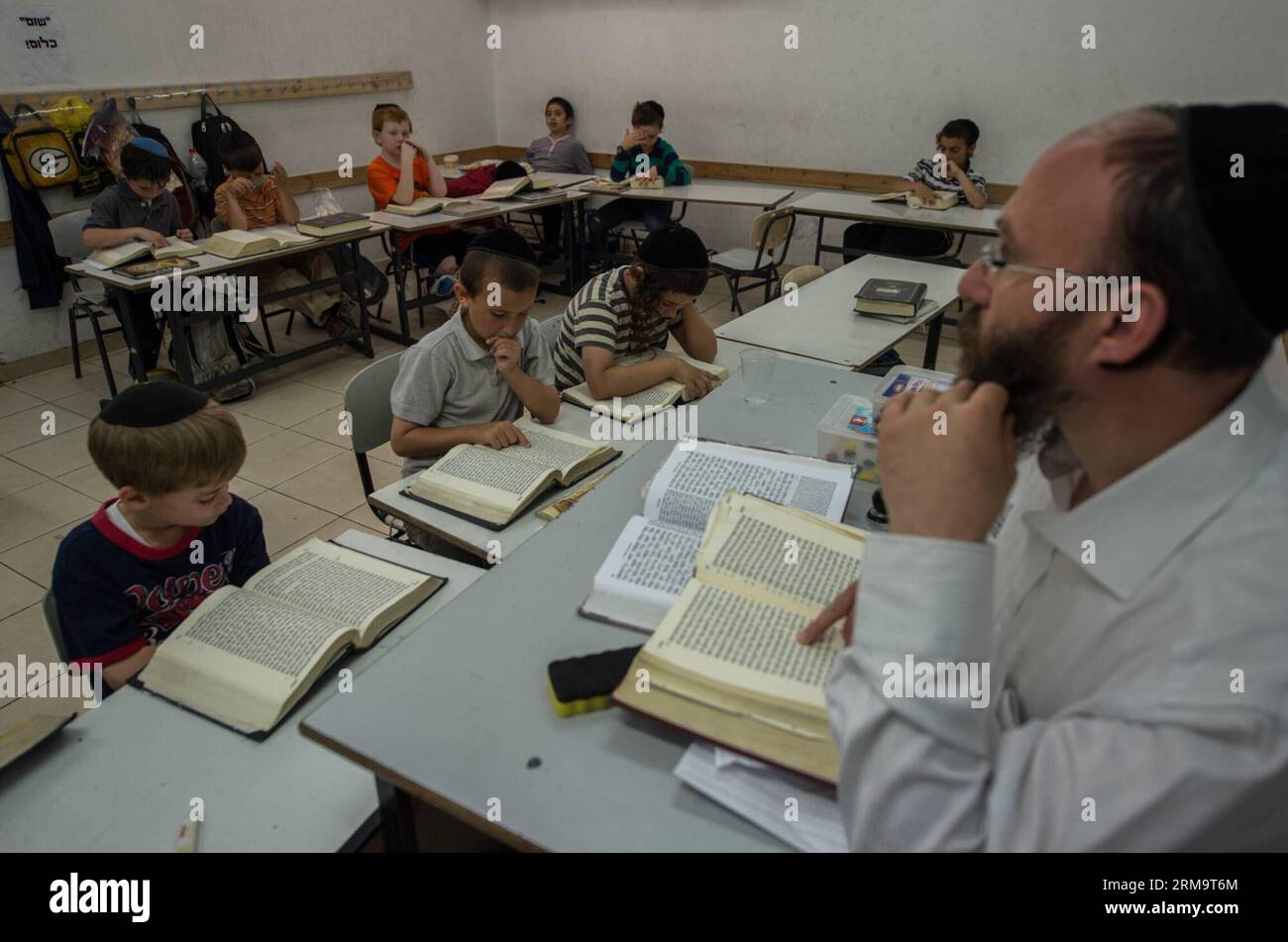 Orthodox Jewish pupils take a class of Jewish religion at Torat Moshe elementary school in Beit Shemesh, about 20 km from Jerusalem, on May 29, 2014. Tzviel Noyman is an Israeli Ultra-Orthodox boy in a family with six children, three boys and three girls. He is ten years old this year and a grade three pupil of Torat Moshe elementary school, which is only opened to Jewish children. Tzviel has eight classes each day, including Hebrew, English, mathematics and Jewish religion, which has four classes each day including Talmud, Mishnah and Gemara. Tzviel likes the religion class best because he th Stock Photo