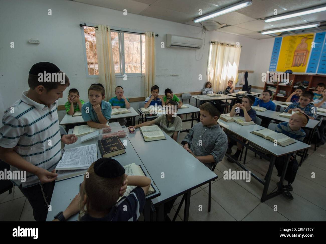 Tzviel Noyman (1st L) leads a class of Jewish religion at Torat Moshe elementary school in Beit Shemesh, about 20 km from Jerusalem, on May 29, 2014. Tzviel Noyman is an Israeli Ultra-Orthodox boy in a family with six children, three boys and three girls. He is ten years old this year and a grade three pupil of Torat Moshe elementary school, which is only opened to Jewish children. Tzviel has eight classes each day, including Hebrew, English, mathematics and Jewish religion, which has four classes each day including Talmud, Mishnah and Gemara. Tzviel likes the religion class best because he th Stock Photo