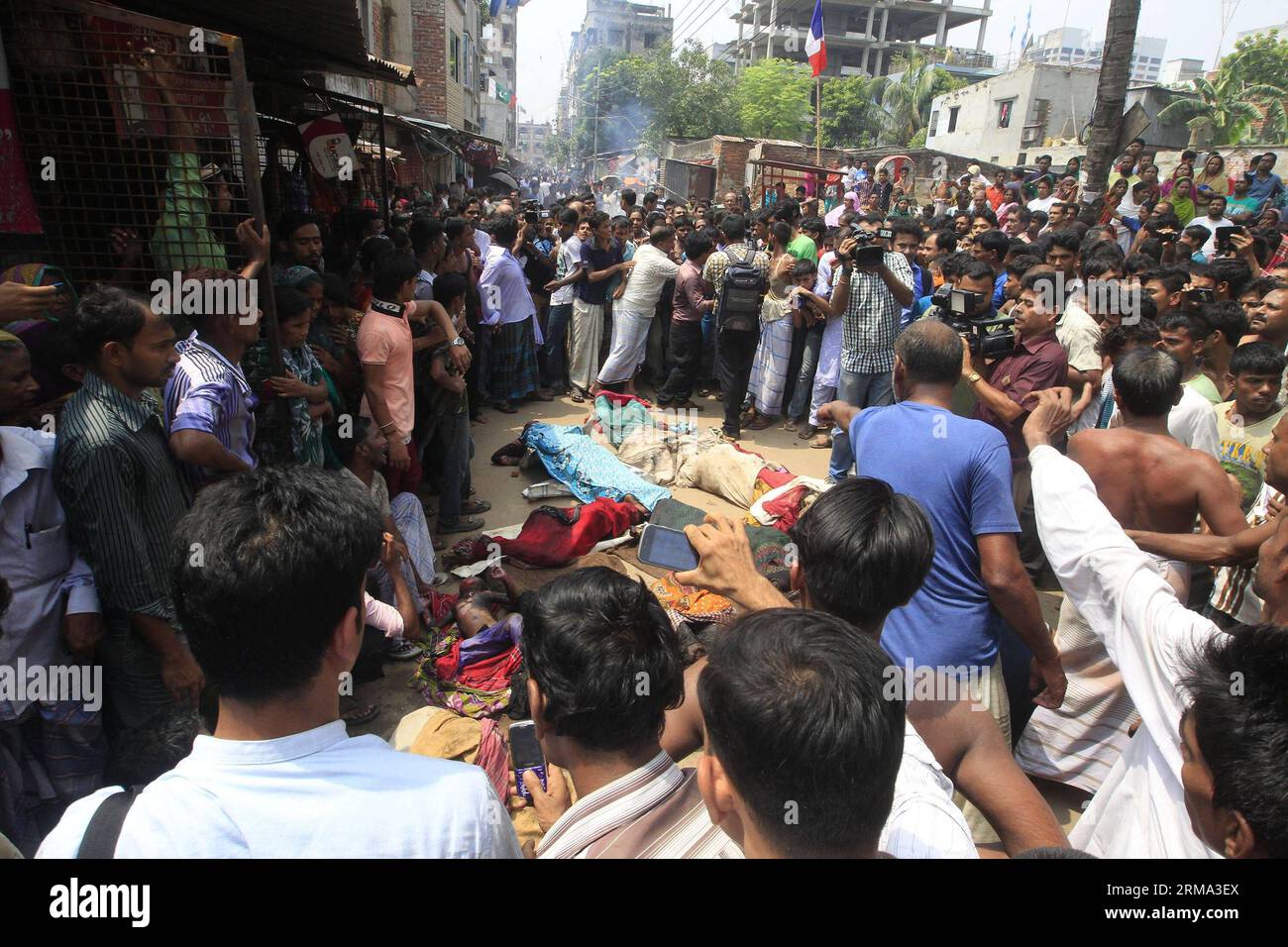 (140614) -- DHAKA, June 14, 2014 (Xinhua) -- Local people watch bodies of victims on a street following a clash at a refugee camp in Dhaka, Bangladesh, June 14, 2014. At least nine people including three children and two women were burnt to death in a devastating fire during a series of violent and chaotic clashes at a refugee camp of Biharis, or stranded Pakistanis in Bangladesh s capital Dhaka on Saturday morning. (Xinhua/Shariful Islam) BANGLADESH-DHAKA-FIRE-REFUGEE PUBLICATIONxNOTxINxCHN   Dhaka June 14 2014 XINHUA Local Celebrities Watch Bodies of Victims ON a Street following a Clash AT Stock Photo