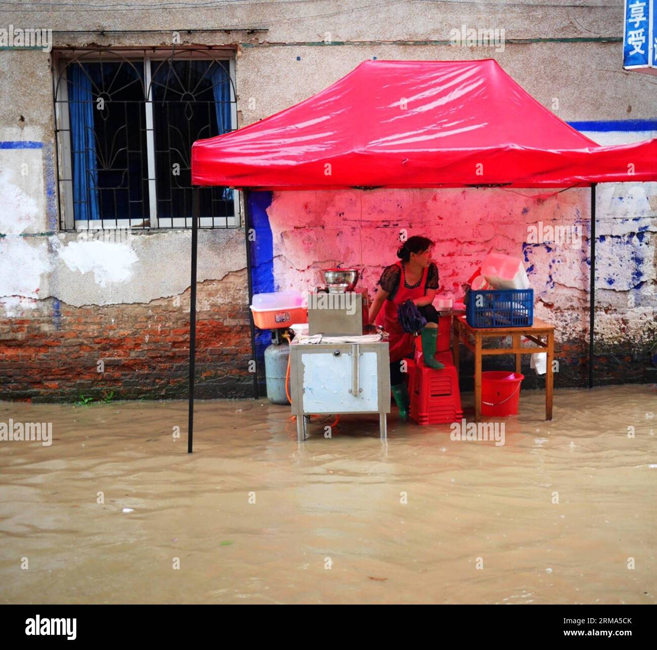 (140618) -- QUANZHOU, June 18, 2014 (Xinhua) -- A woman sells breakfast on a flooded road in Quanzhou County of Guilin City, south China s Guangxi Zhuang Autonomous Region, June 18, 2014. A rainstorm hit seven counties and cities of Guilin on Wednesday. (Xinhua/Liang Qian) (lfj) CHINA-GUANGXI-GUILIN-WATERLOGGING (CN) PUBLICATIONxNOTxINxCHN   Quanzhou June 18 2014 XINHUA a Woman sells Breakfast ON a flooded Road in Quanzhou County of Guilin City South China S Guangxi Zhuang Autonomous Region June 18 2014 a Rainstorm Hit Seven Counties and CITIES of Guilin ON Wednesday XINHUA Liang Qian  China G Stock Photo
