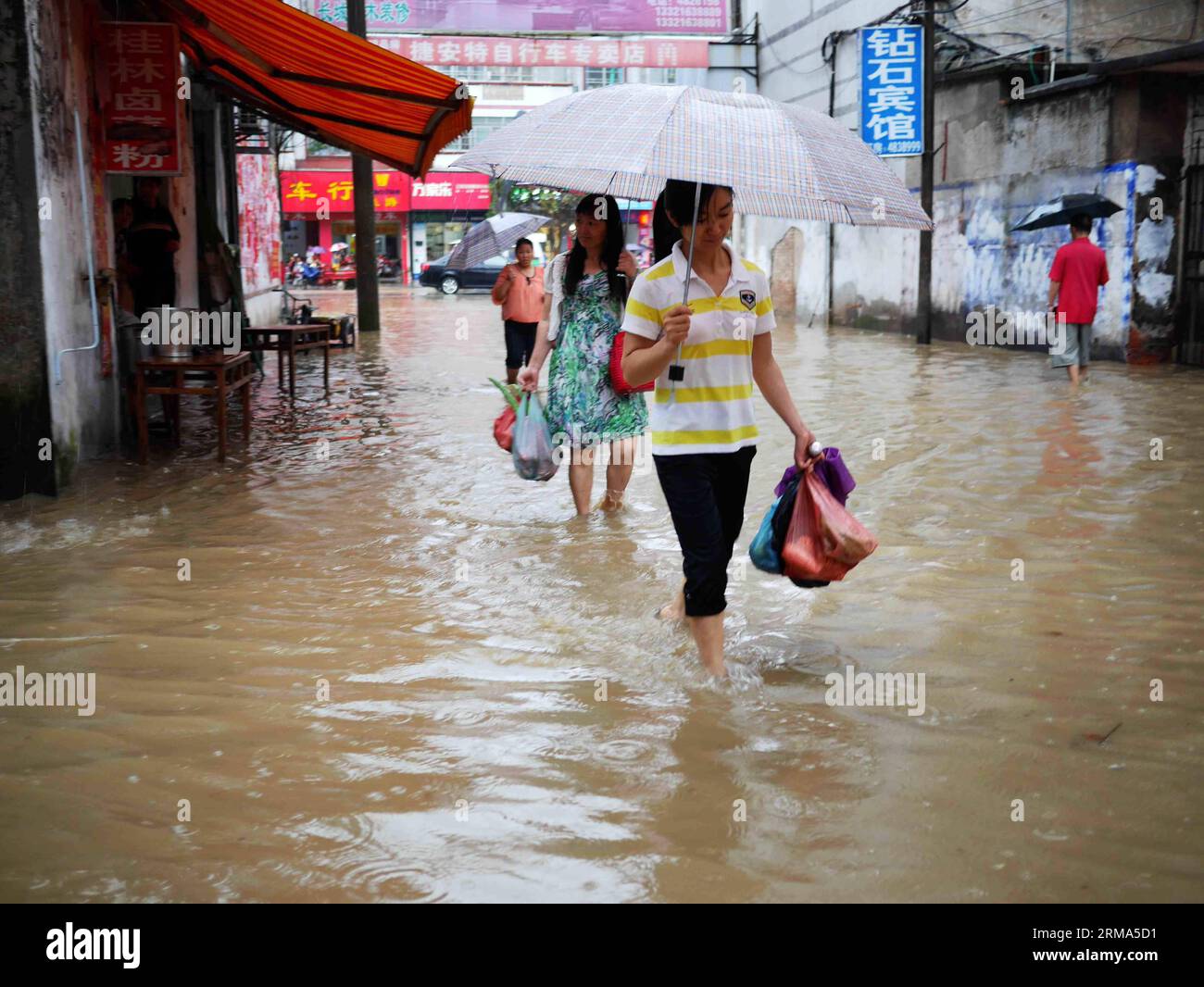 (140618) -- QUANZHOU, June 18, 2014 (Xinhua) -- Residents walk on a flooded road in Quanzhou County of Guilin City, south China s Guangxi Zhuang Autonomous Region, June 18, 2014. A rainstorm hit seven counties and cities of Guilin on Wednesday. (Xinhua/Liang Qian) (lfj) CHINA-GUANGXI-GUILIN-WATERLOGGING (CN) PUBLICATIONxNOTxINxCHN Quanzhou June 18 2014 XINHUA Residents Walk ON a flooded Road in Quanzhou County of Guilin City South China S Guangxi Zhuang Autonomous Region June 18 2014 a Rainstorm Hit Seven Counties and CITIES of Guilin ON Wednesday XINHUA Liang Qian China Guangxi Guilin wate Stock Photo